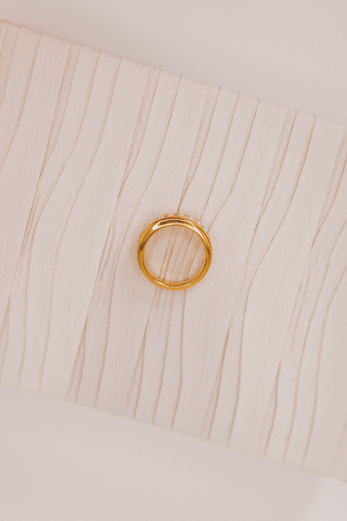 Gold ring with asymmetrical pearl line