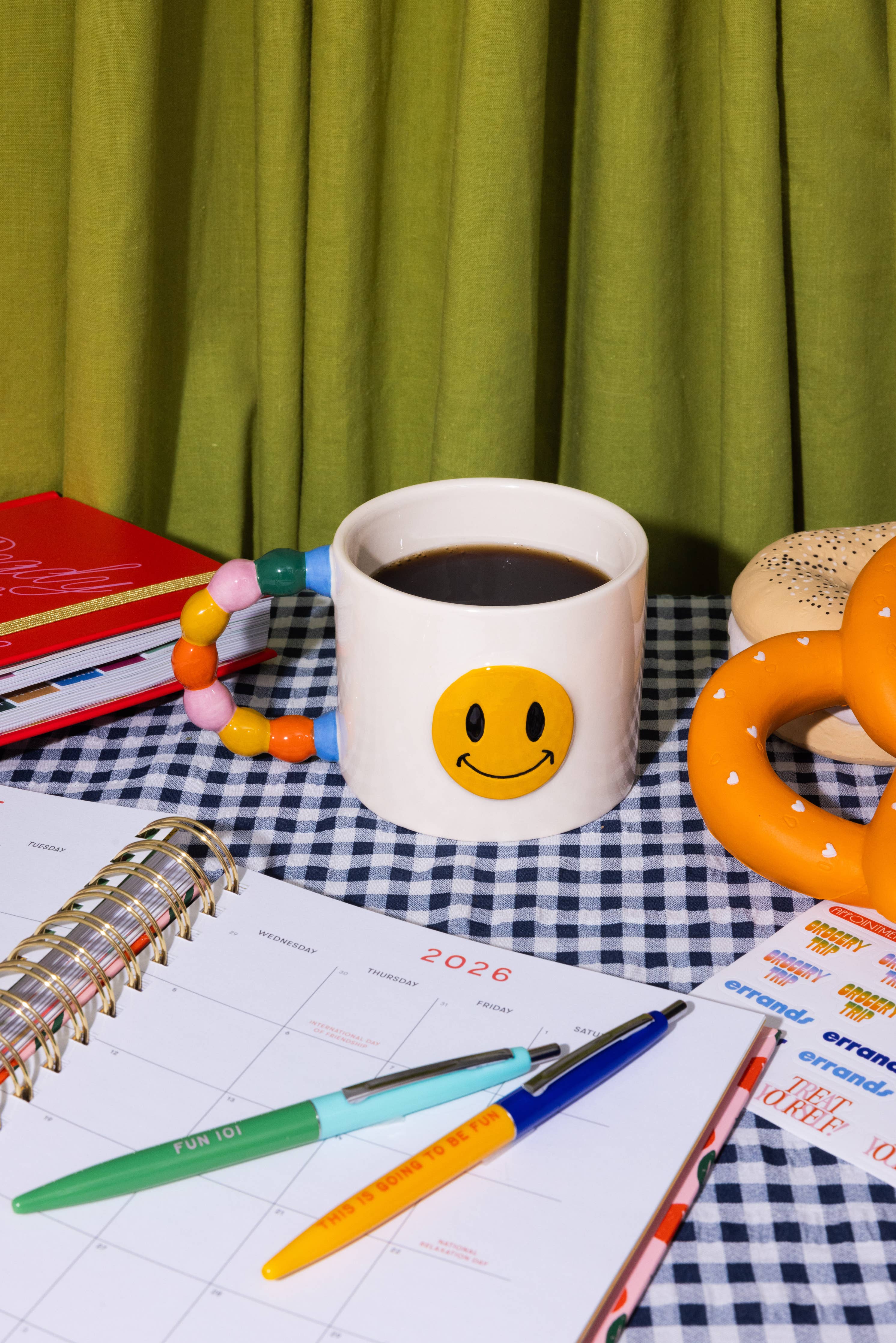 white smiley face mug with rainbow handle
