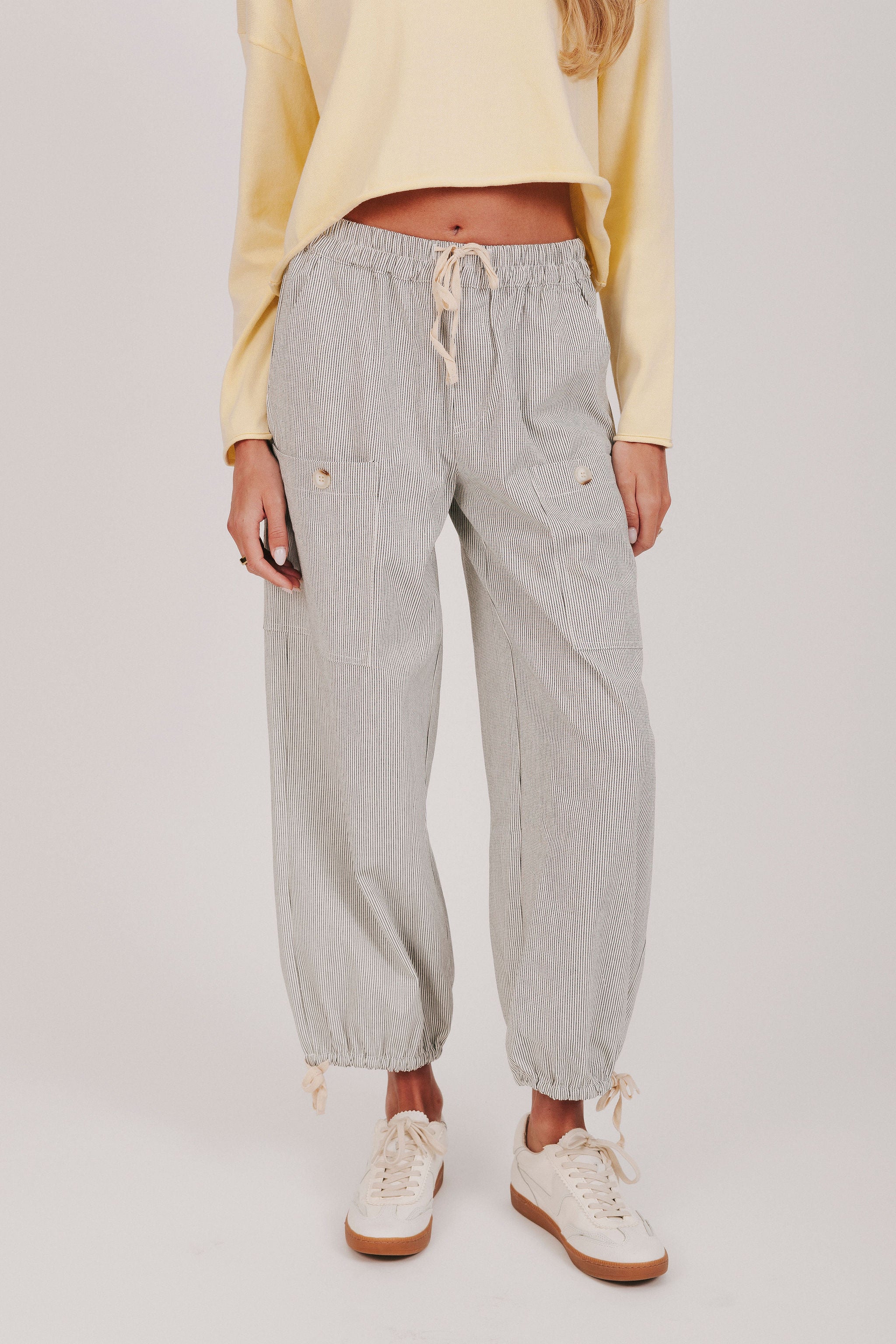 Black and white vertically striped pants with pockets and tied bow detail