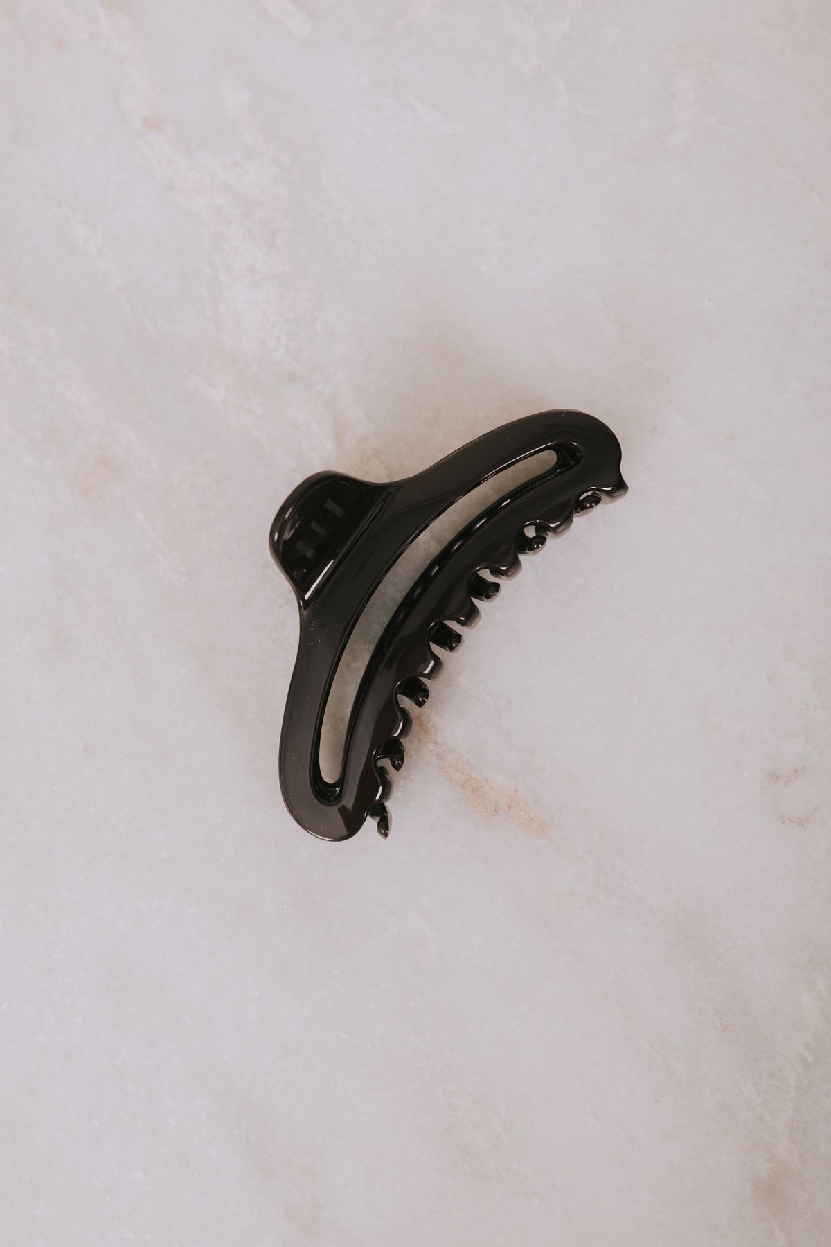 brown curved claw clip flatlay