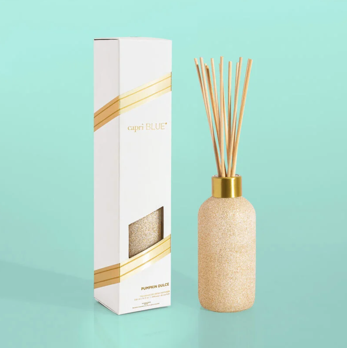 Decorative diffuser bottle with gold accents and packaging in pumpkin