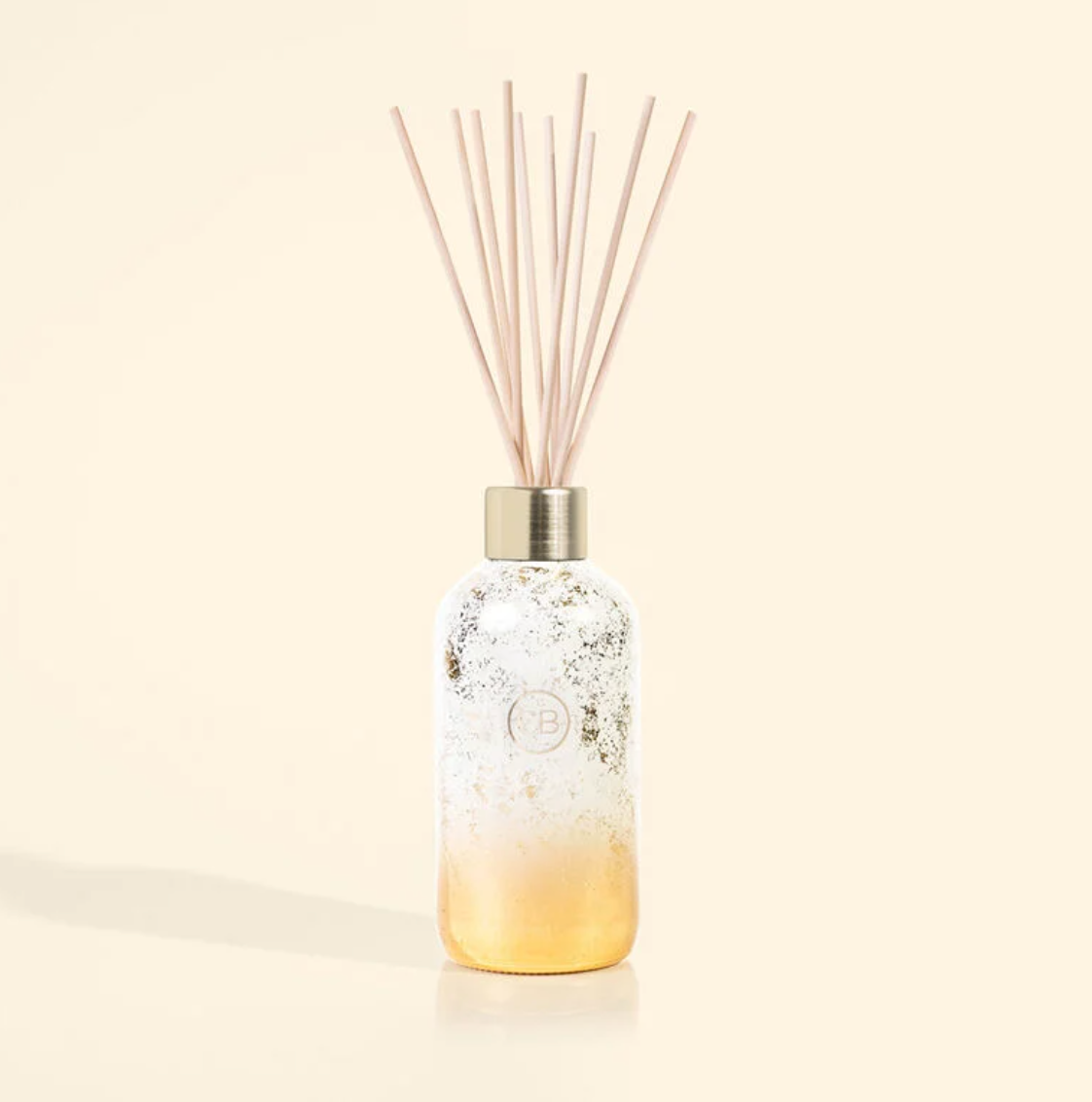 Reed diffuser with white and gold ombre design in volcano scent.