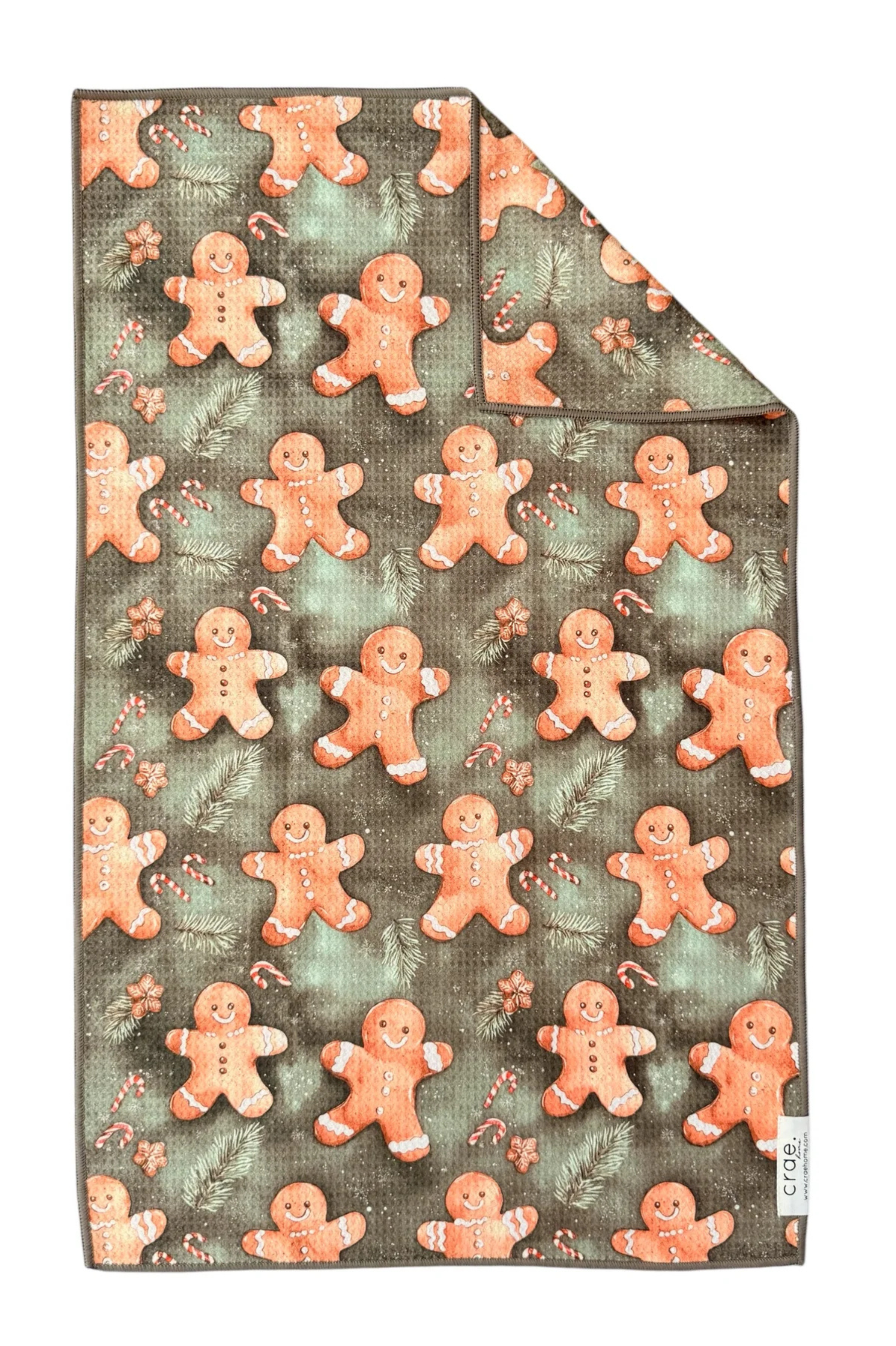 Gingerbread man patterned microfiber hand towel with a green background