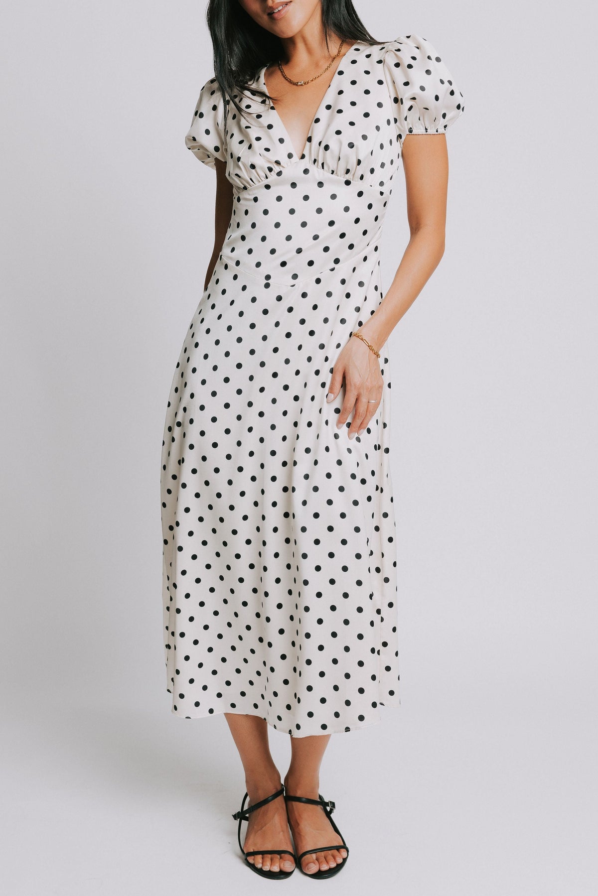 cream and black polka dot dress with v neck and puffed sleeves