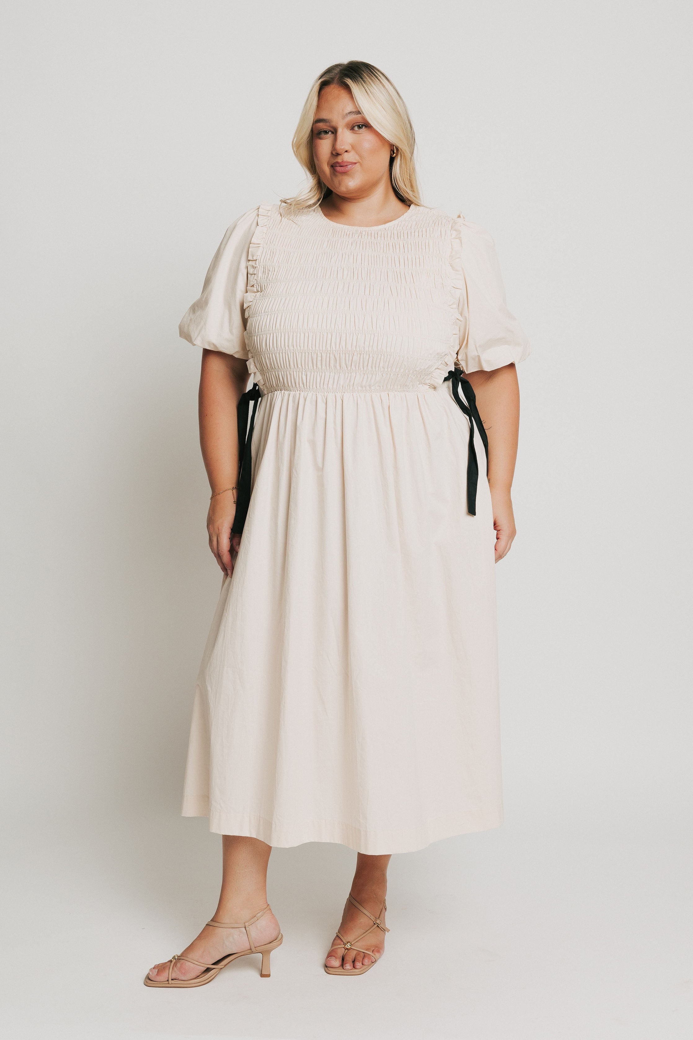 cream midi dress with black bow accents