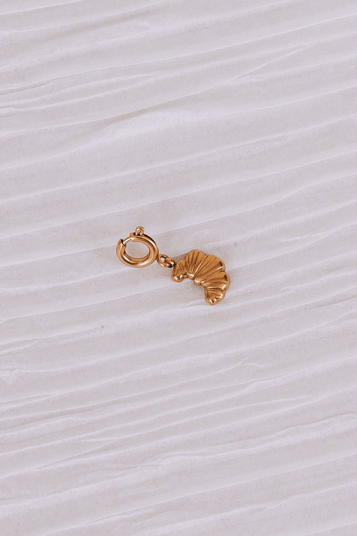 Gold charm shaped like a croissant