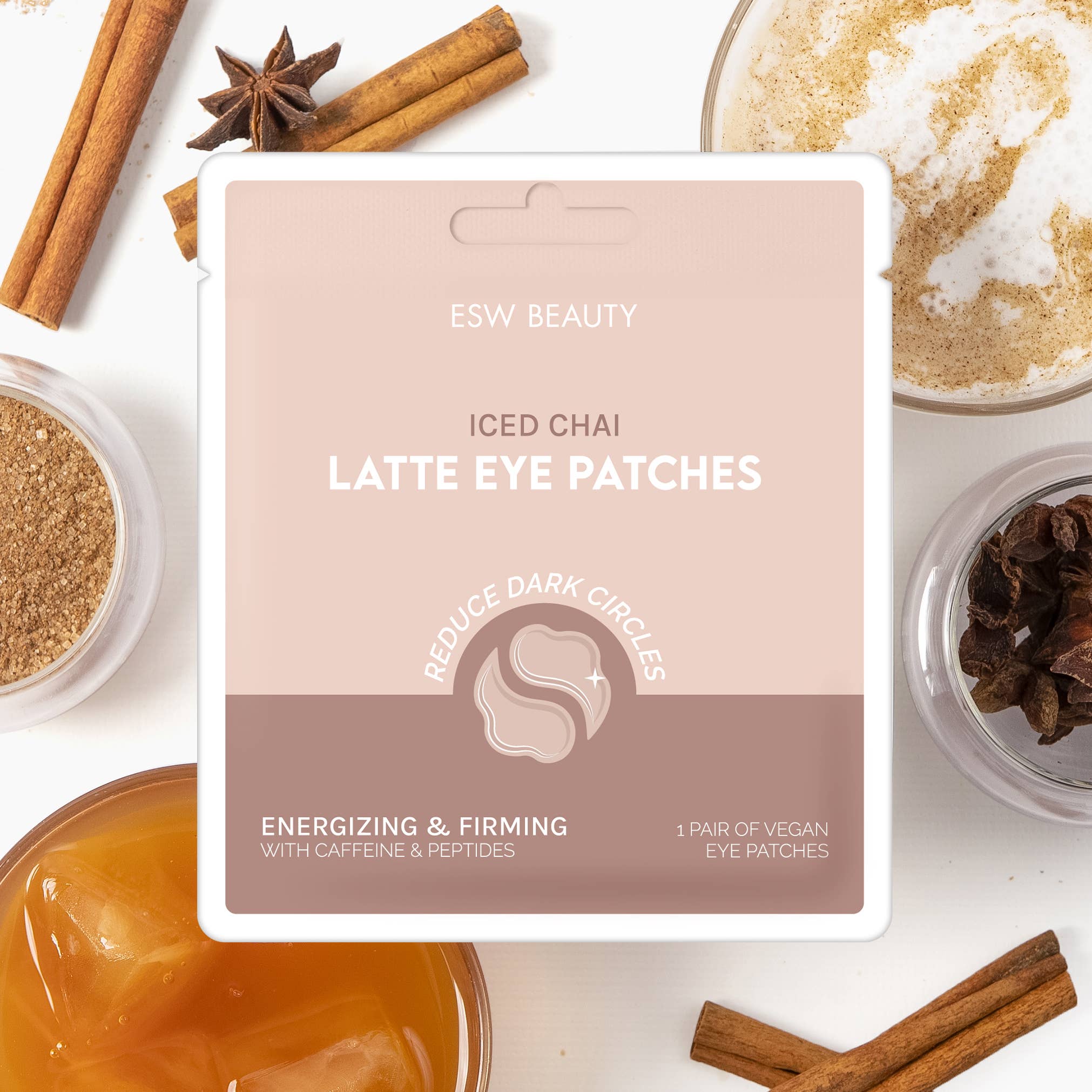 Packaging of 'Iced Chai Latte Energizing & Firming Eye Patches' by ESW Beauty, displayed with ingredients like cinnamon sticks, anise star, and patches themselves, against a white background.