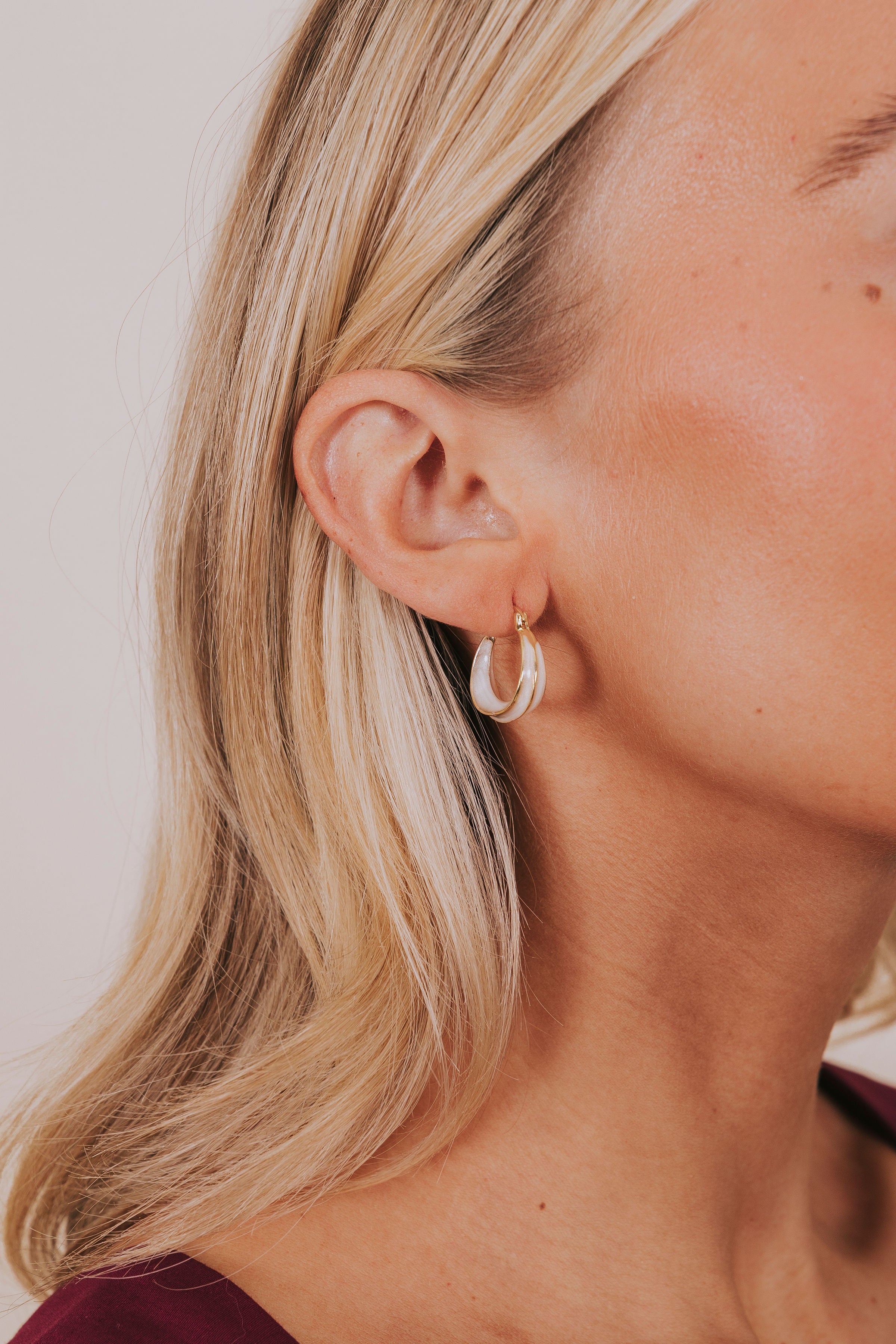 gold and off white hoop earrings worn