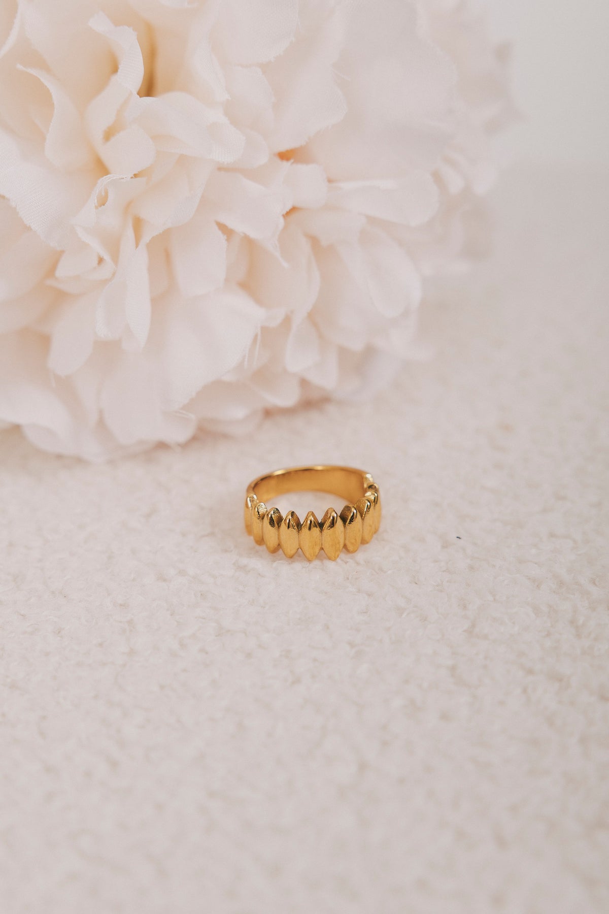 gold ring with diamond design flat lay