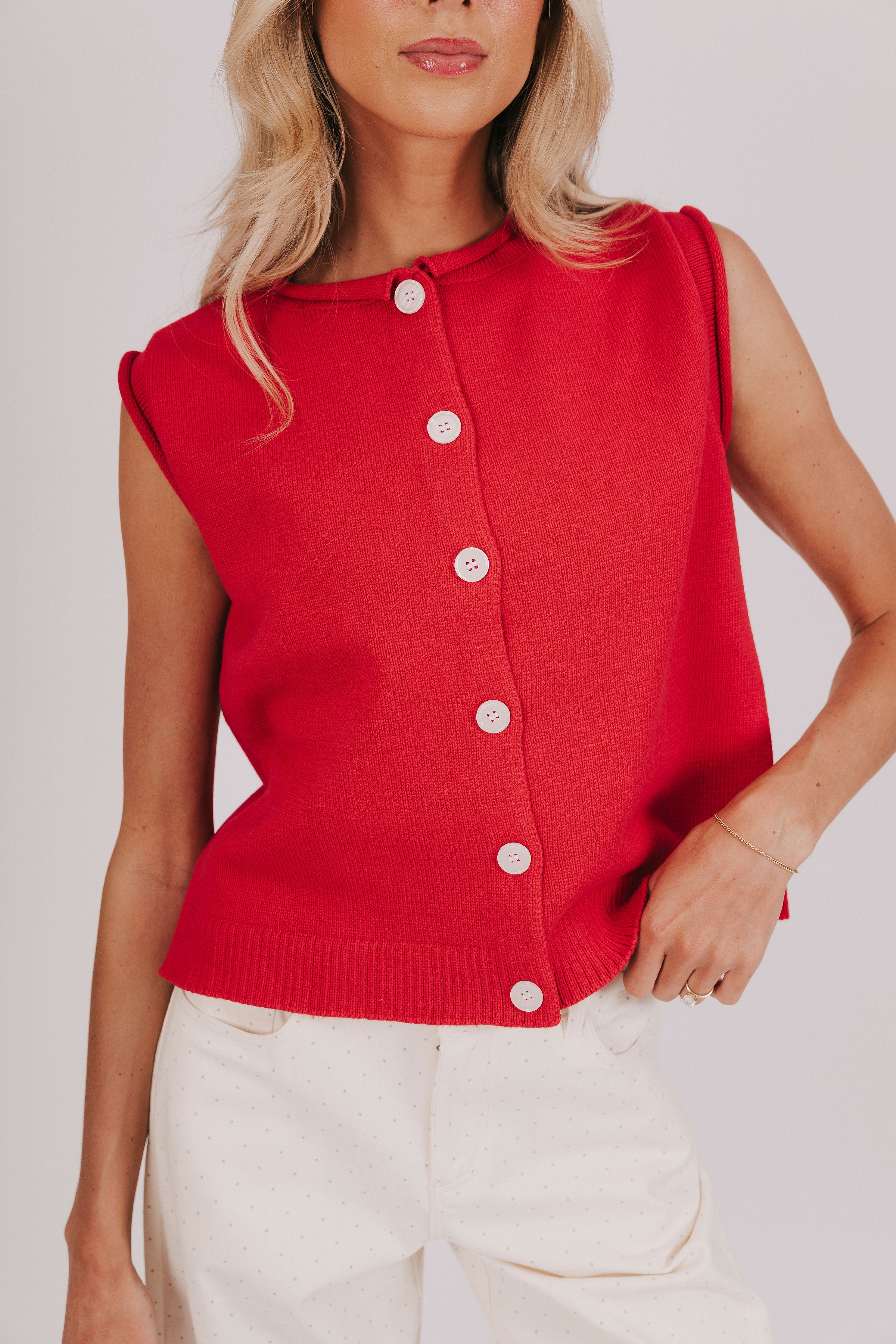 red sleeveless knit top with a button down front and rolled edges