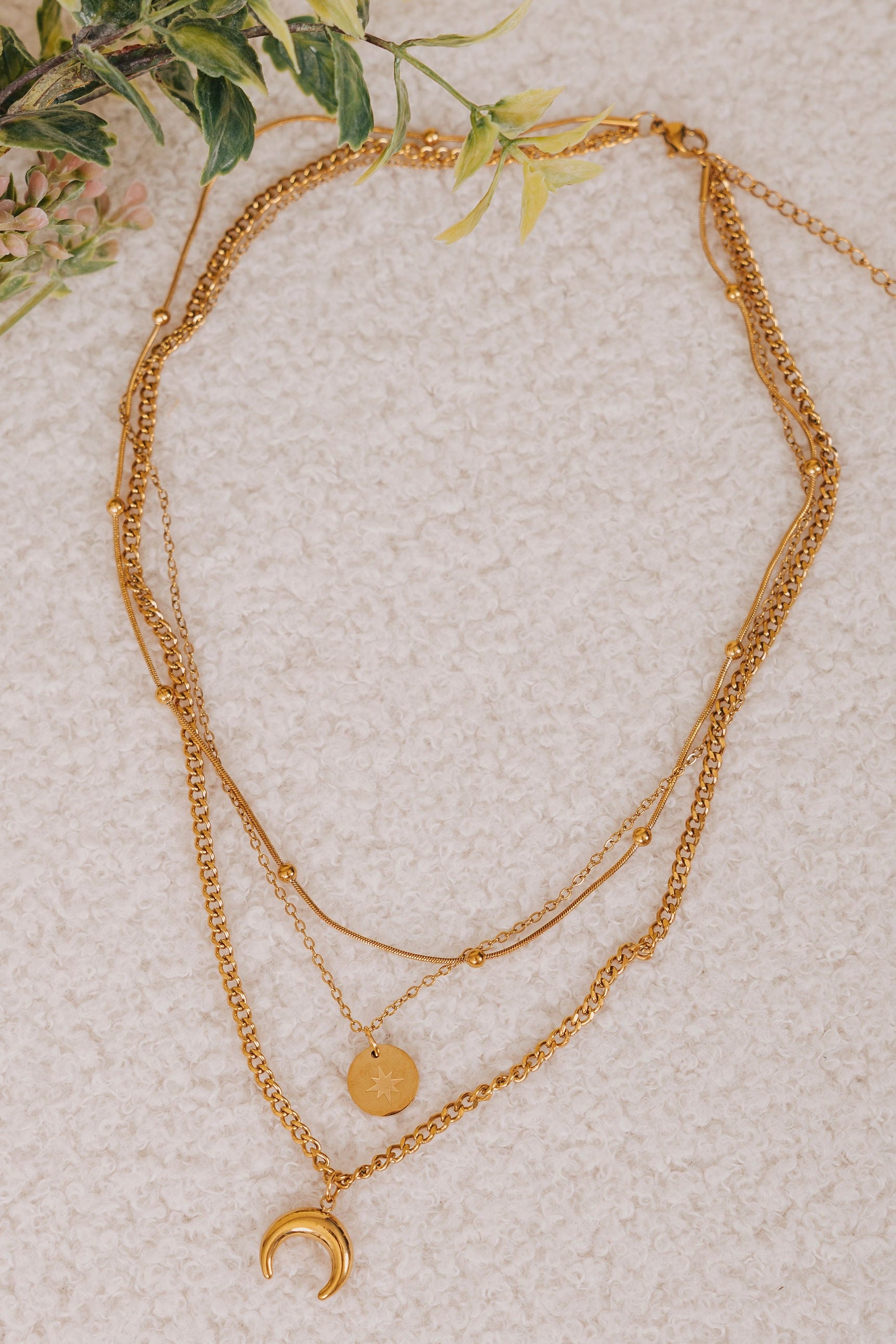 gold triple layered necklace with moon and star sun pendants