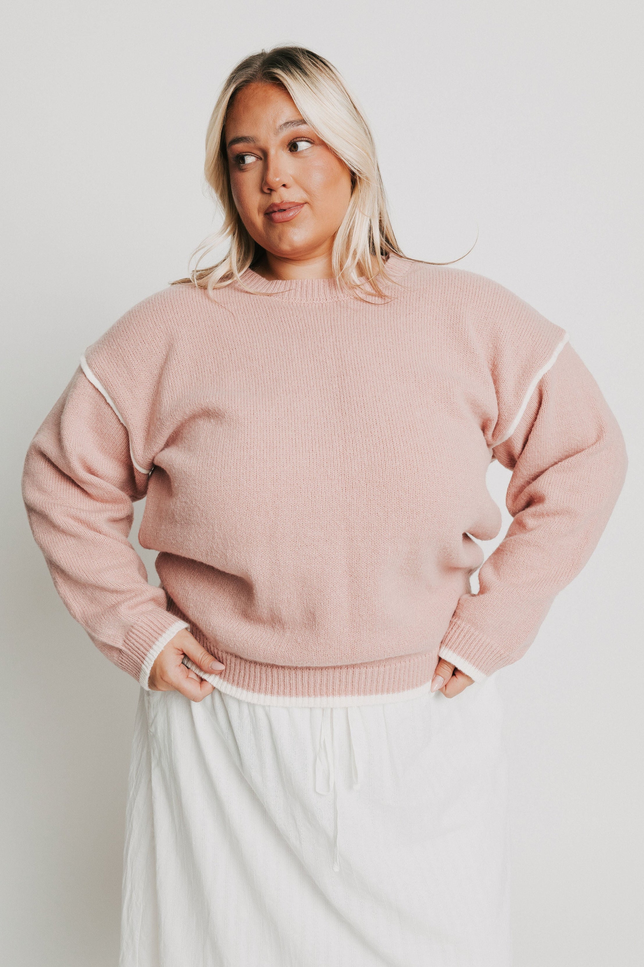 pink crewneck sweater with white trim