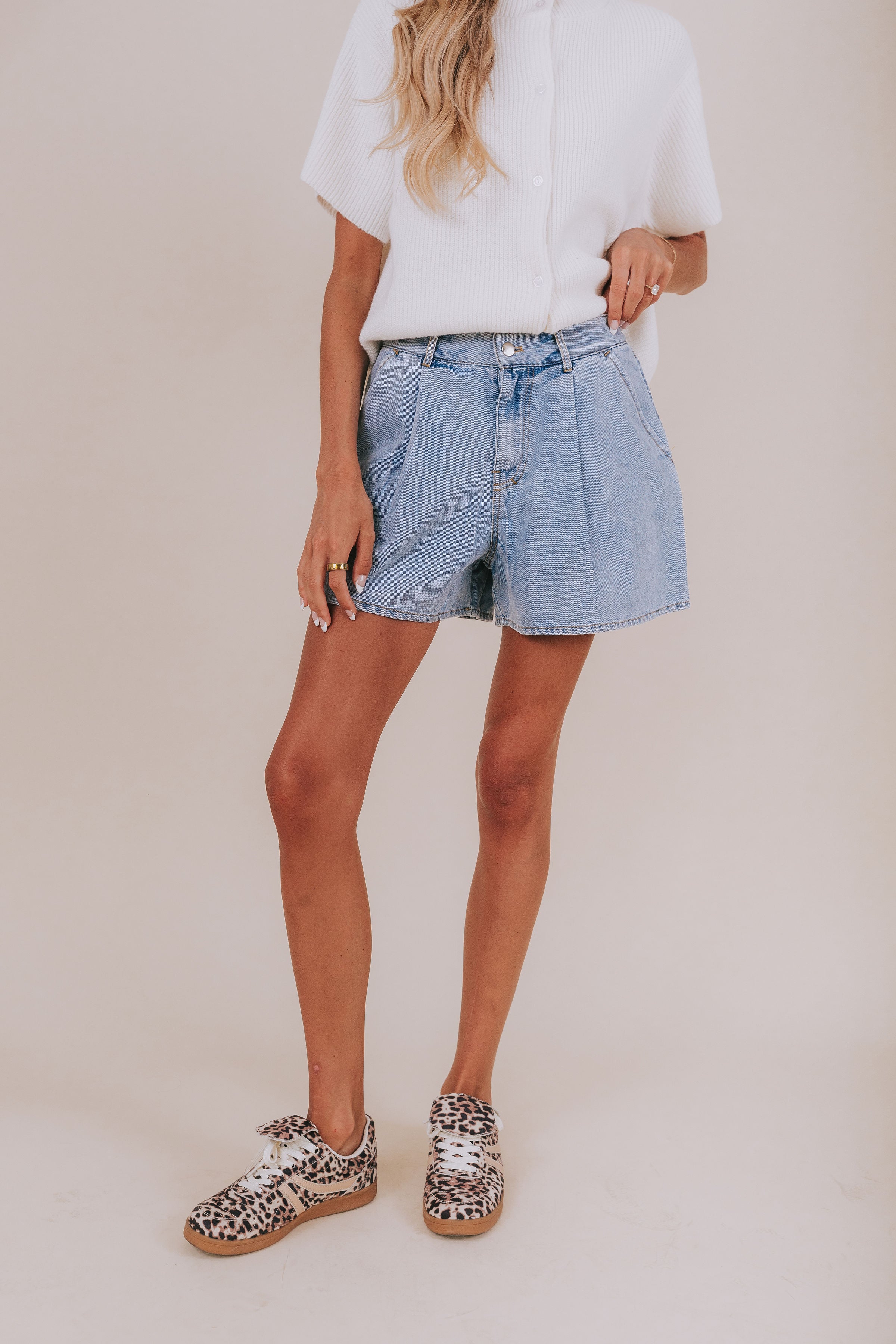 Light wash jean shorts that reach upper-thigh length and have belt loops.