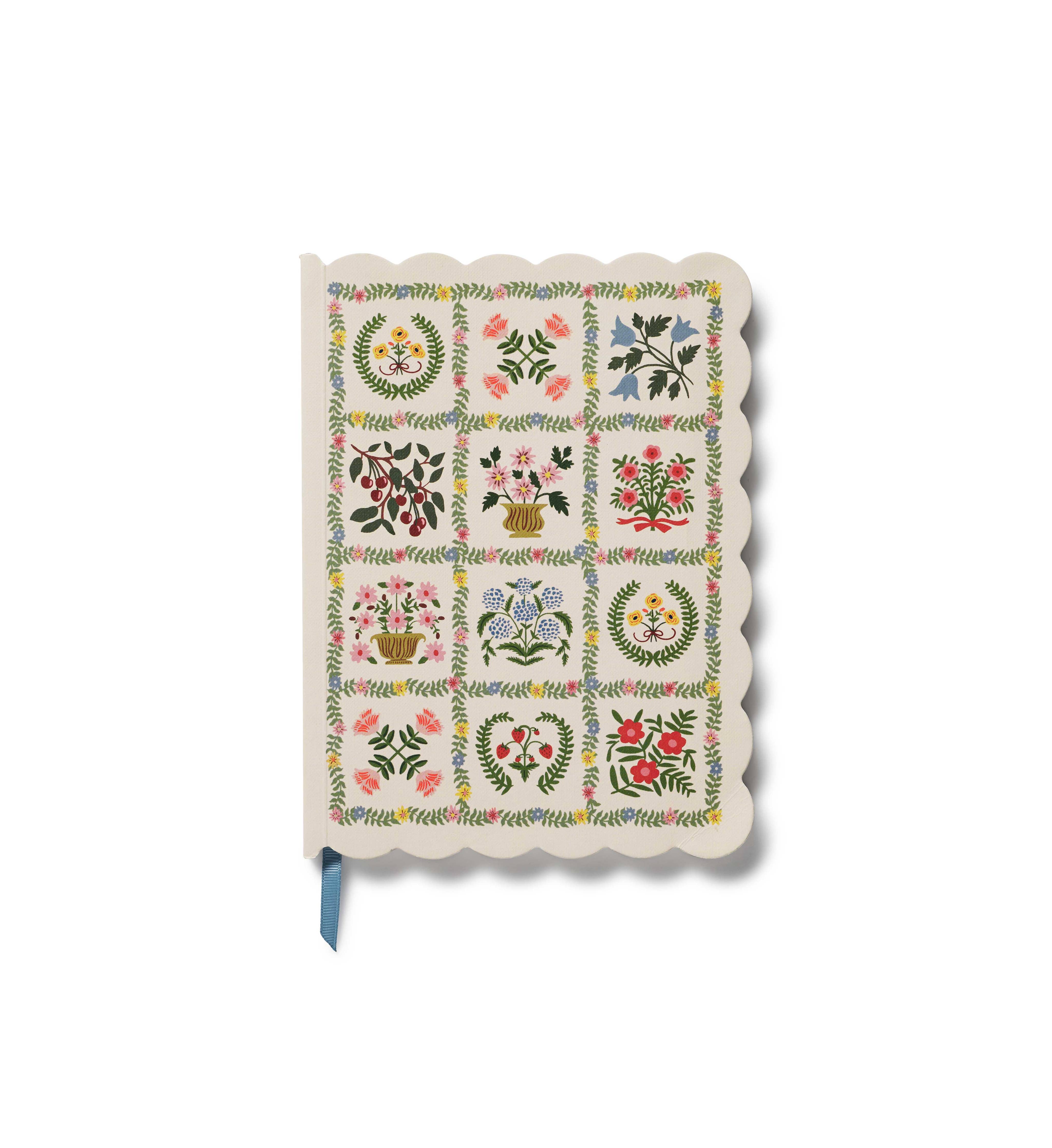Softcover notebook with floral designs and a scalloped edge.