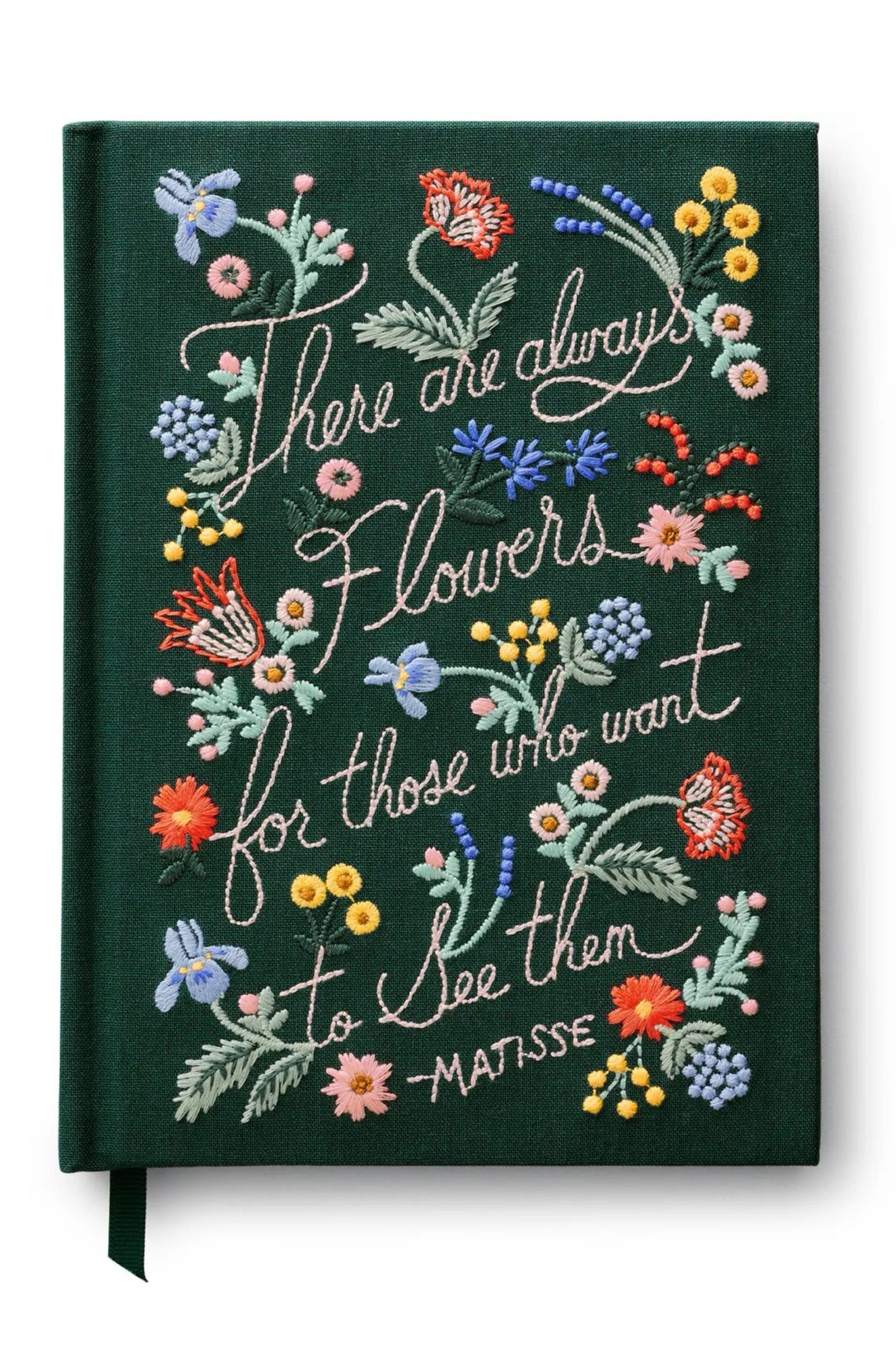 Decorative notebook with floral embroidery and Matisse quote on a dark green background.