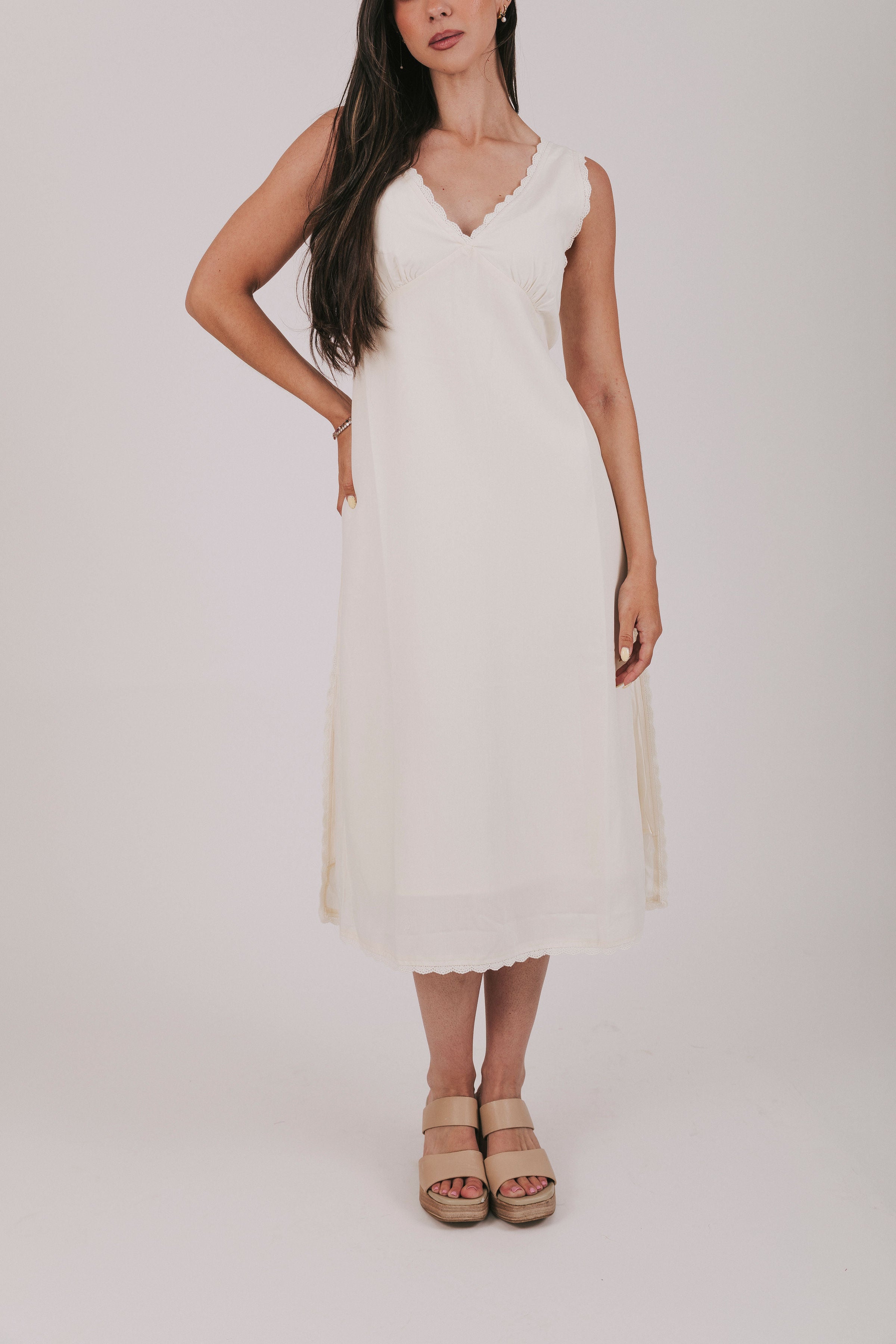 Midi dress that comes in 2 colors, off white and light blue. Sleeveless design with lace trim and side slits.