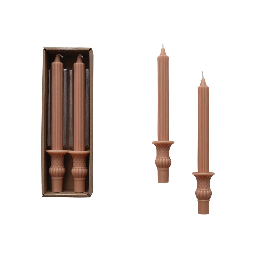 A set of decorative taper candles in a box.