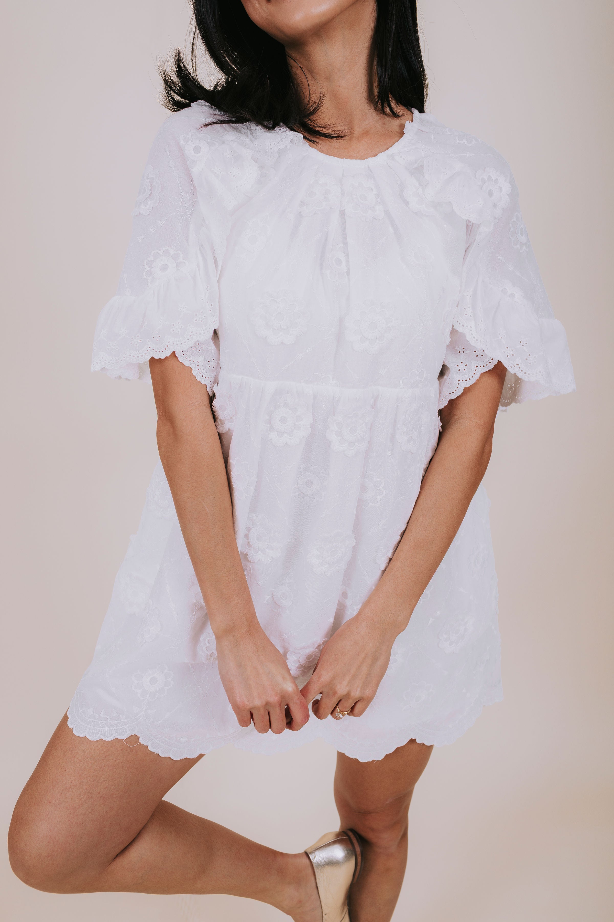 White mini dress with eyelet details, embroidered flowers and scalloped trim