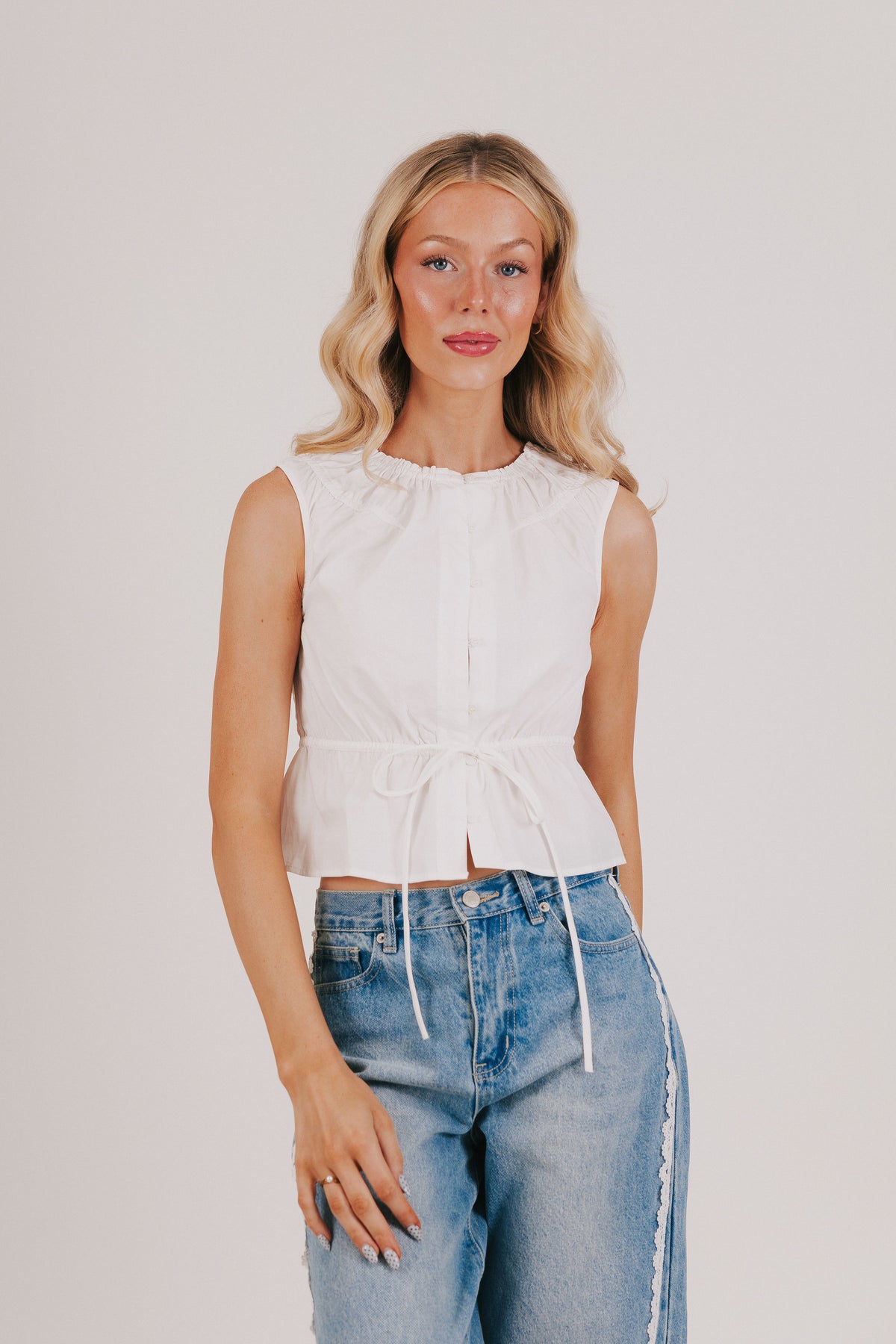white sleeveless top with tie at the waist