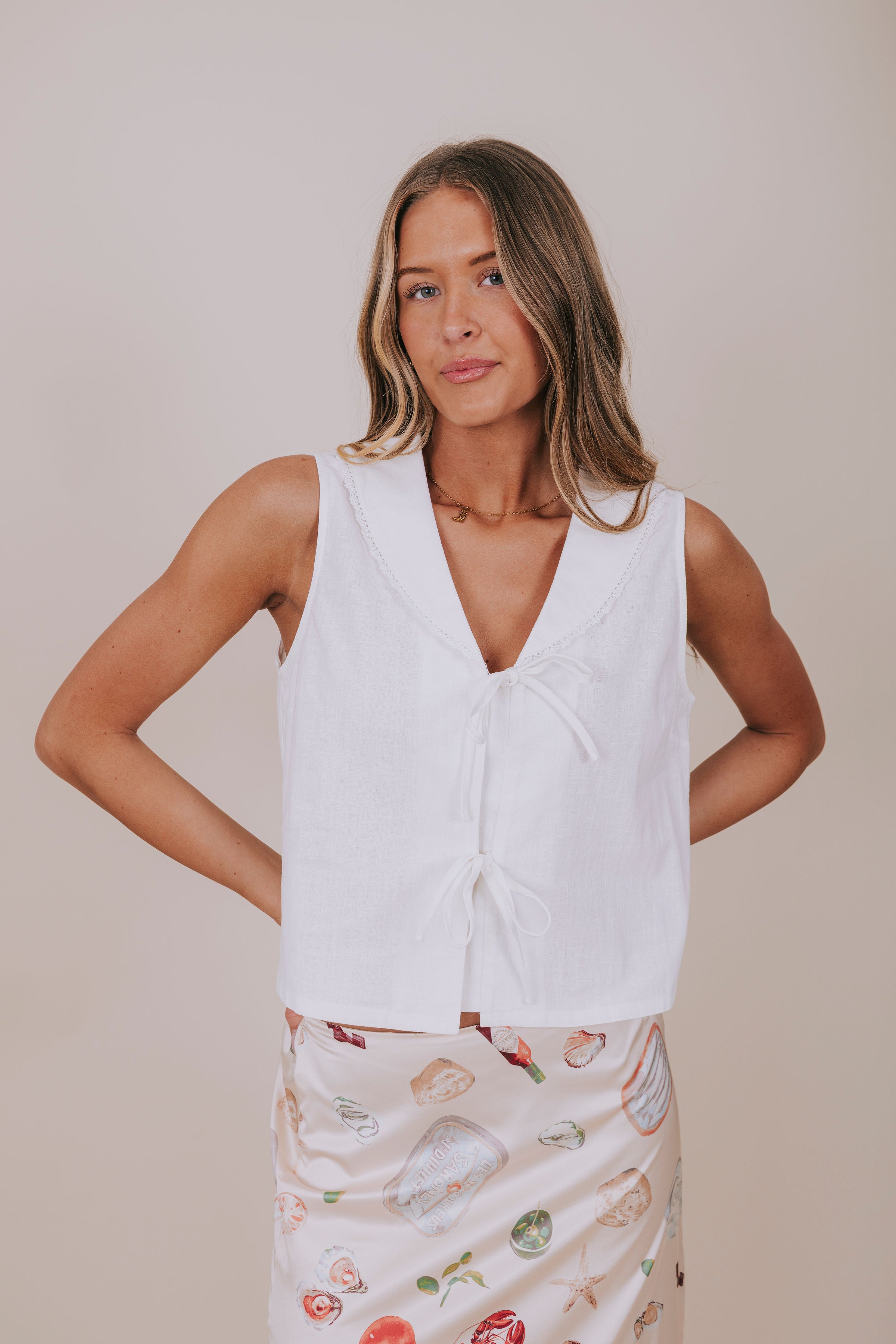 white sleeveless vest with bows front