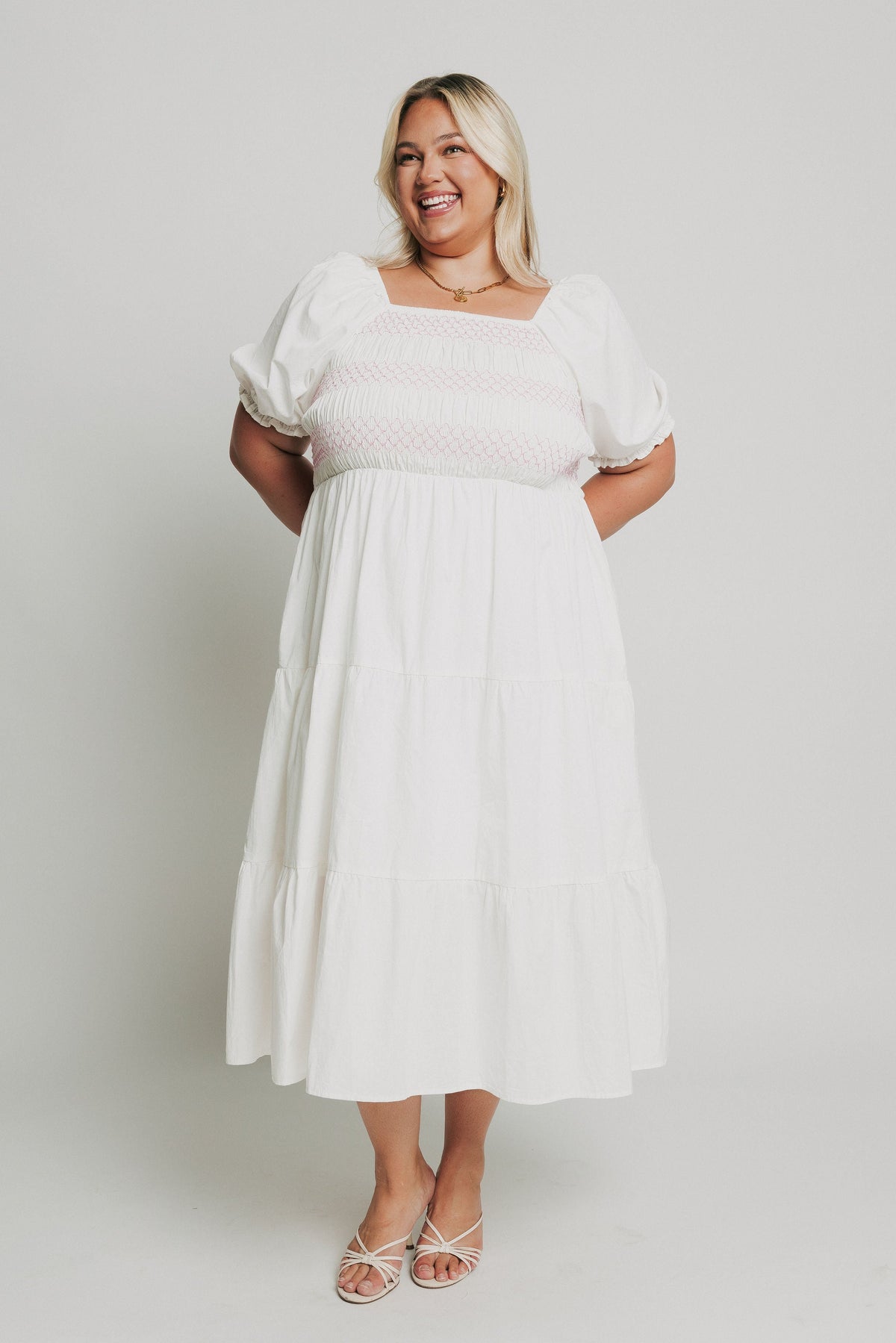 white tiered midi dress with pink embroidery on bodice