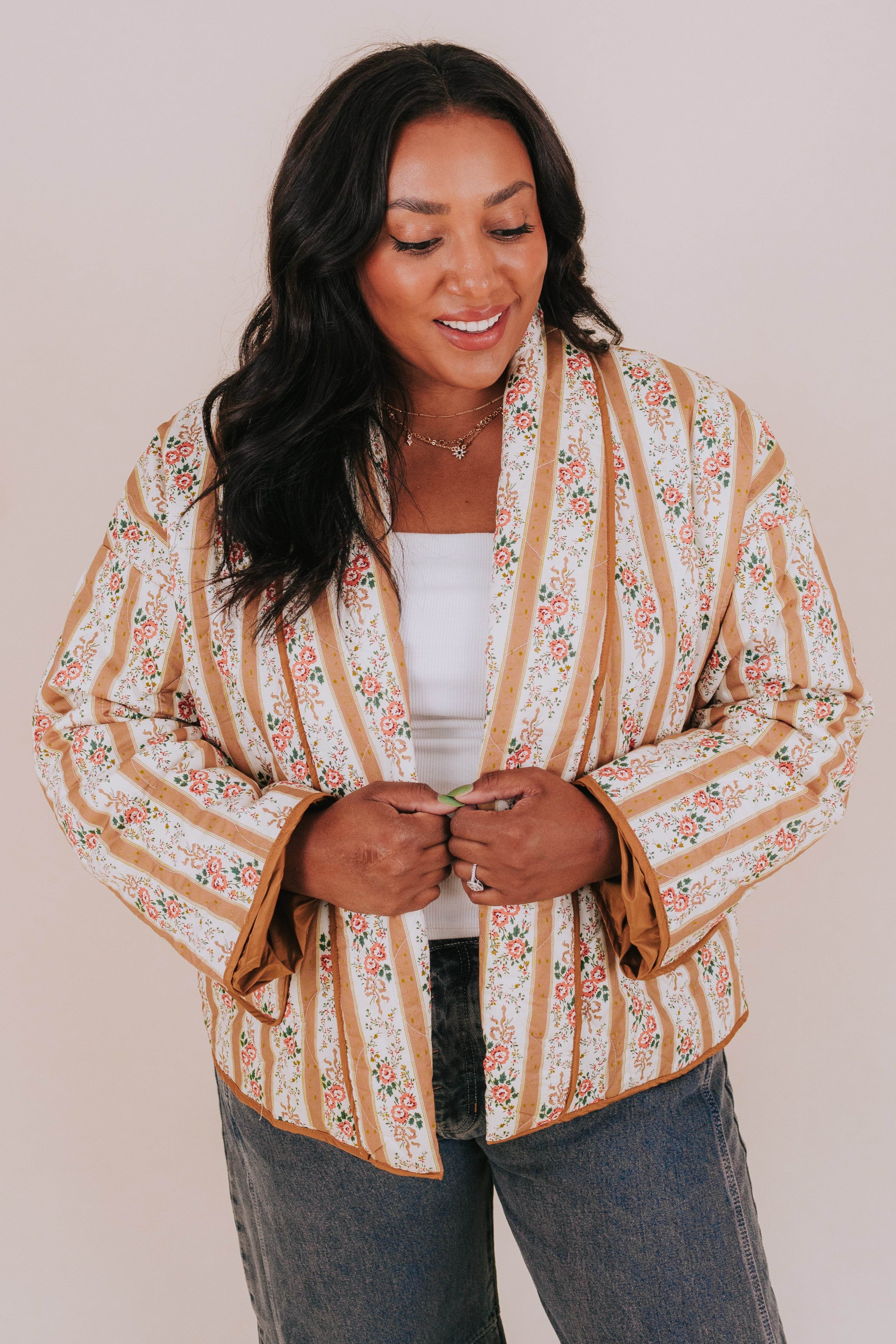 Woman wearing a floral and striped jacket against a plain background