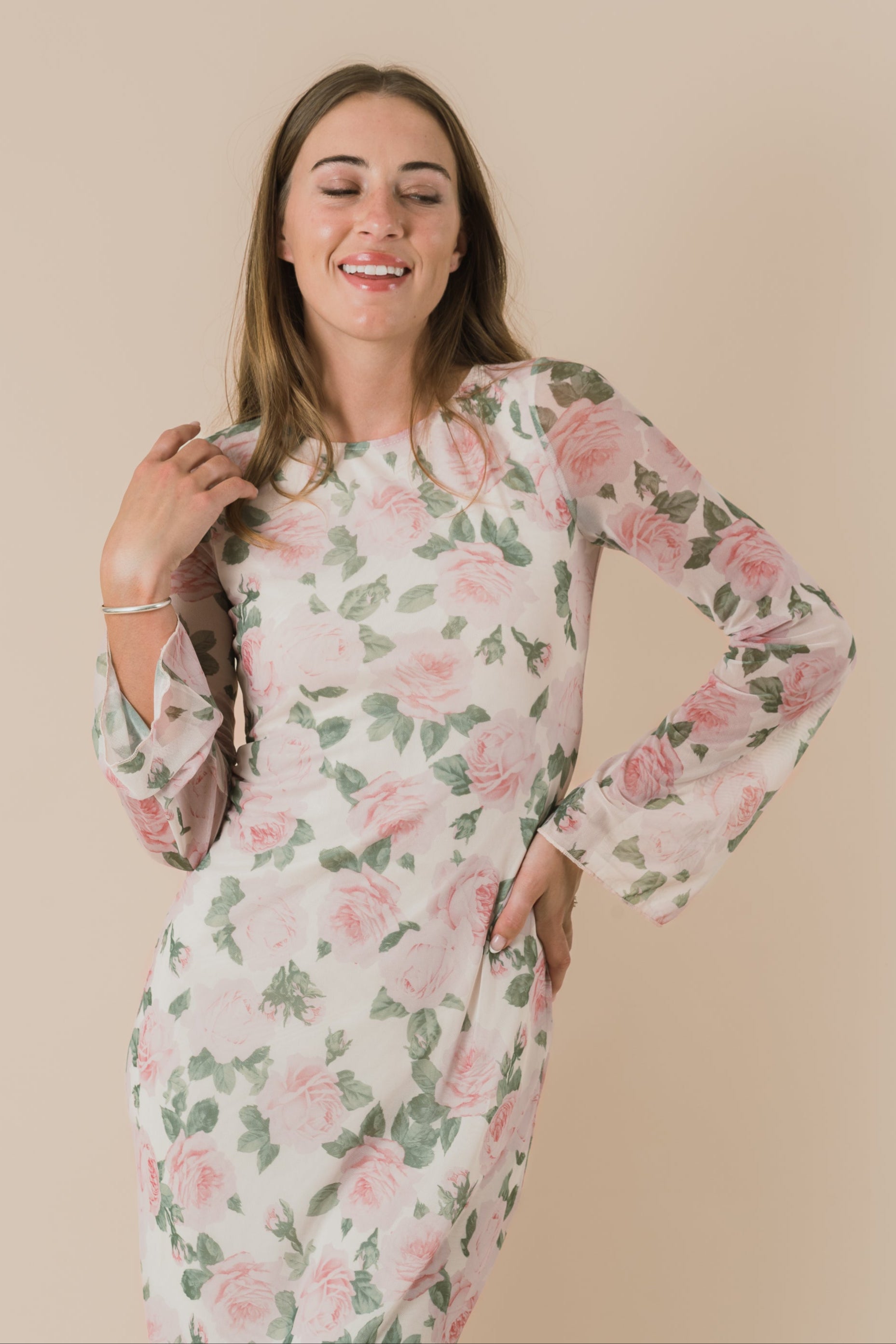 Woman wearing a floral dress against a beige background