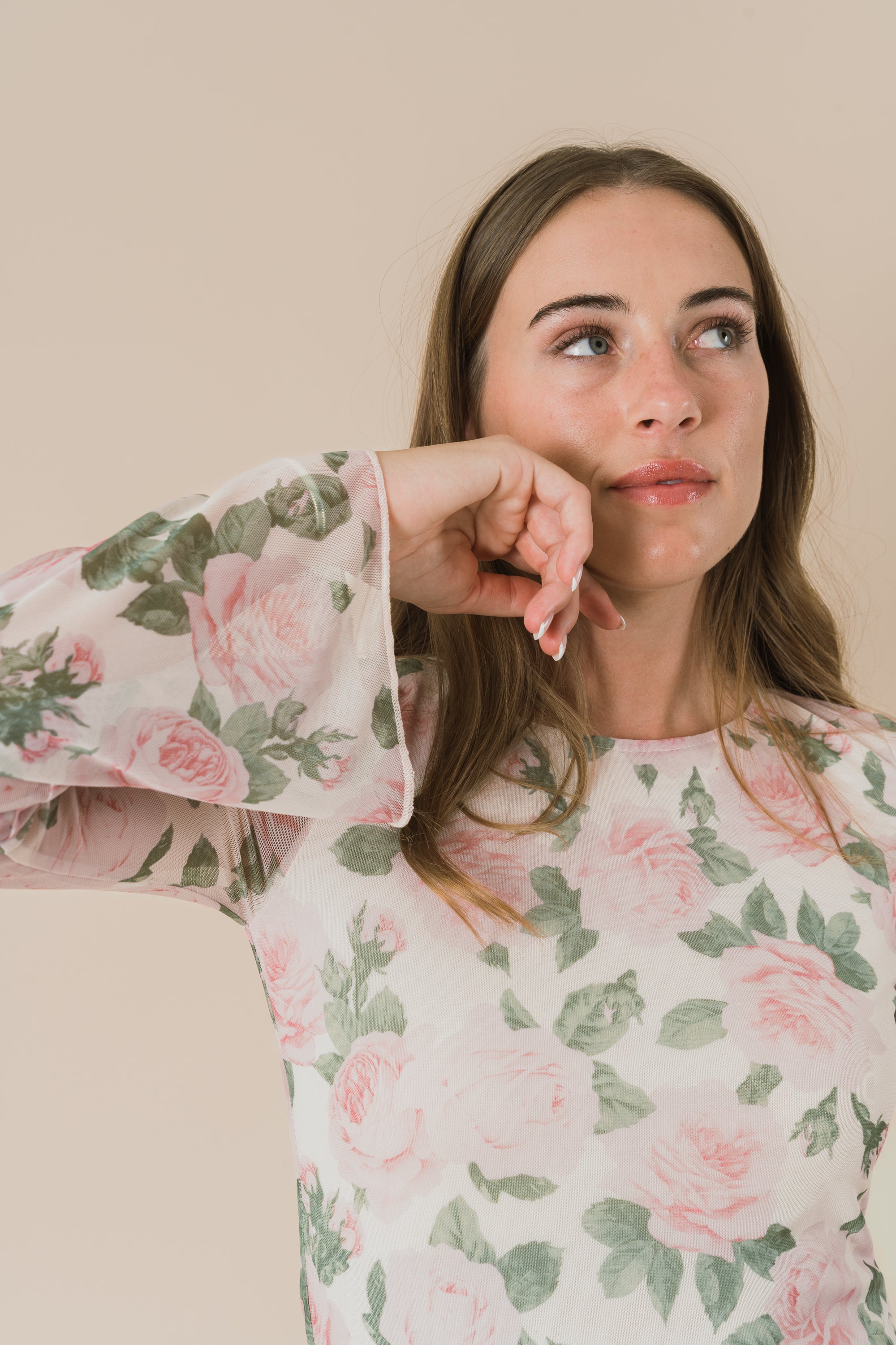 Woman wearing a floral dress with a neutral background