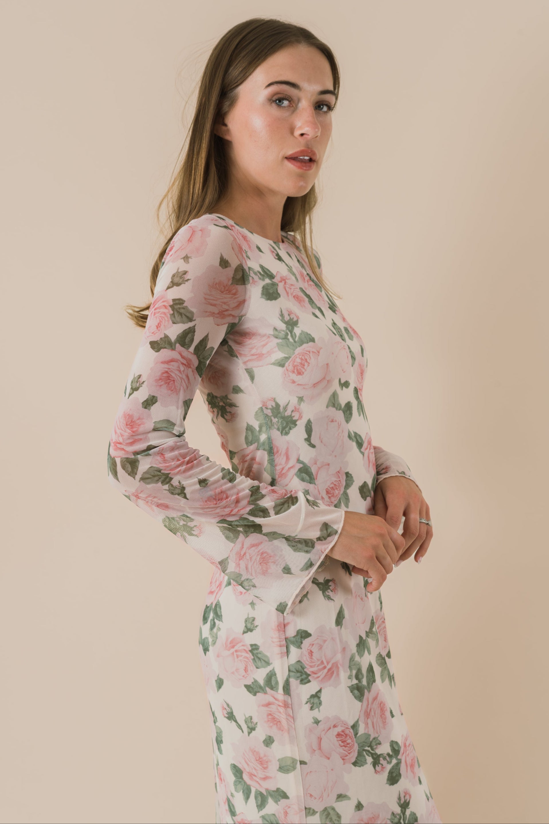 Woman wearing a floral dress against a beige background