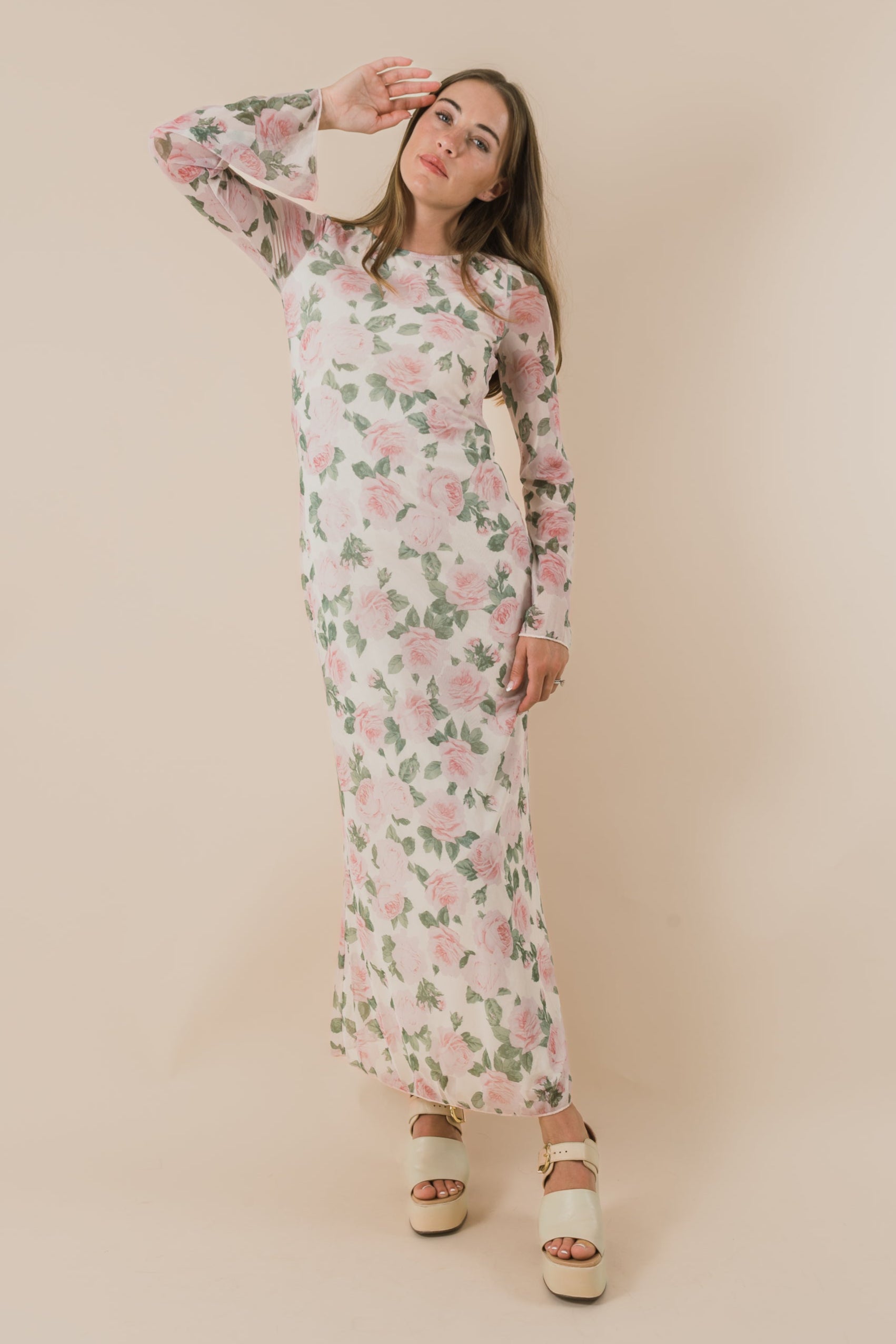 Woman wearing a floral dress against a beige background