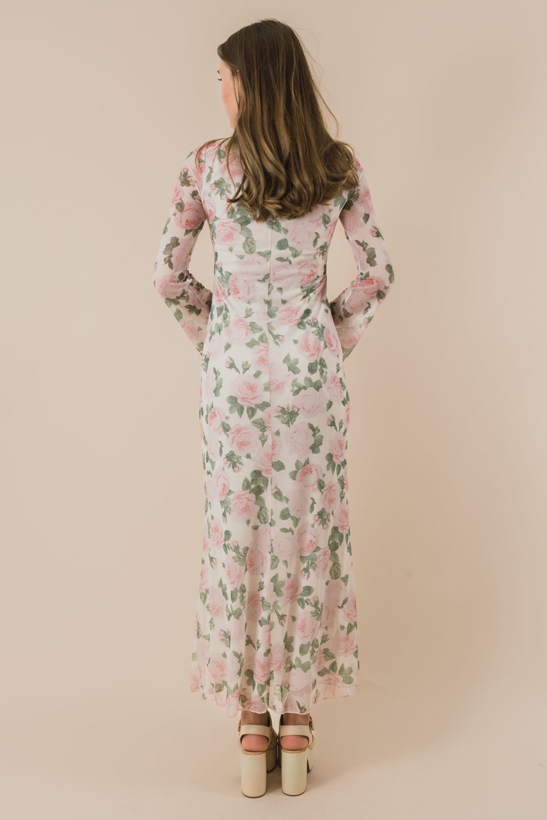 Woman wearing a floral dress against a beige background