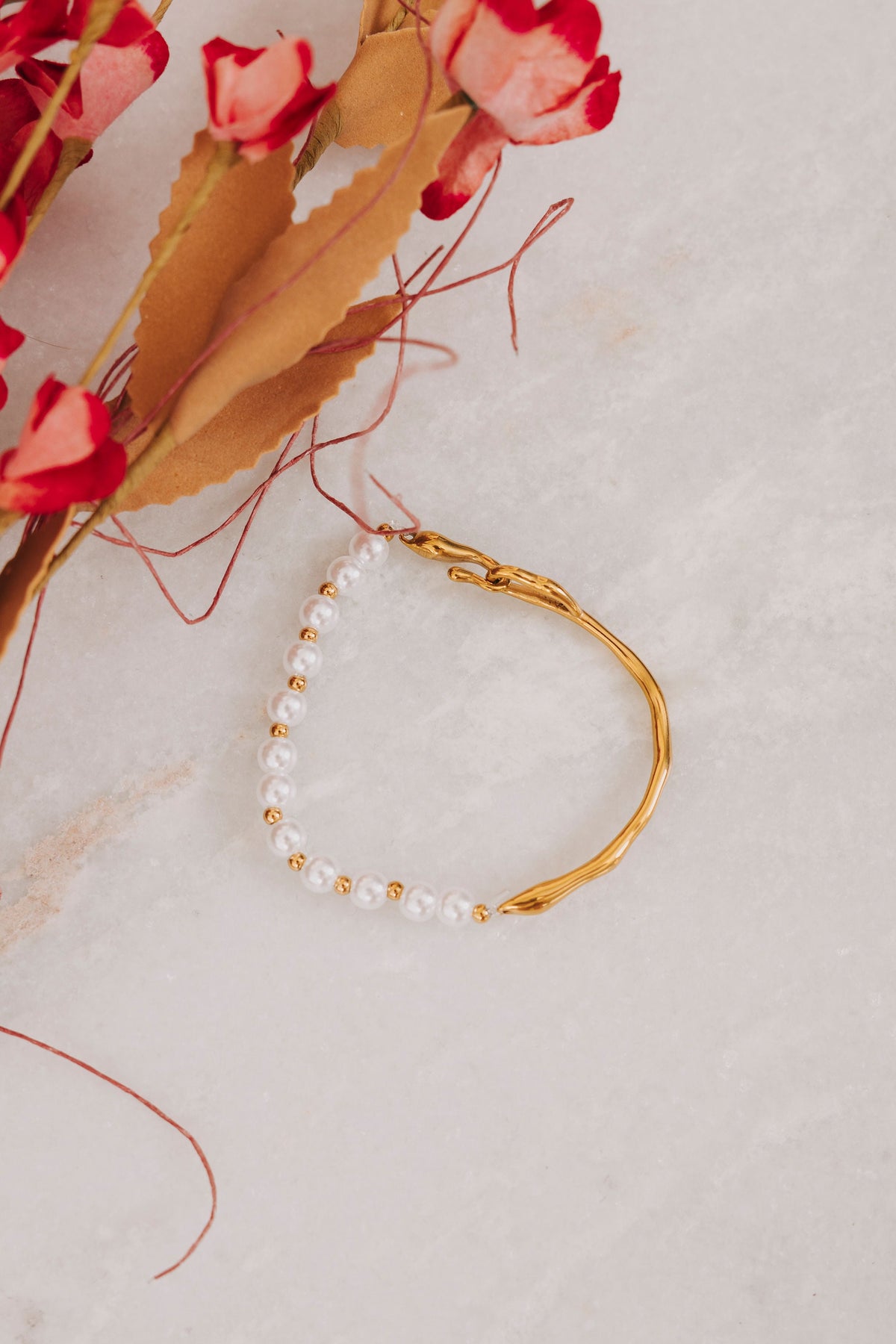 Asymmetrical bracelet with half gold and half pearl with gold bead accents 