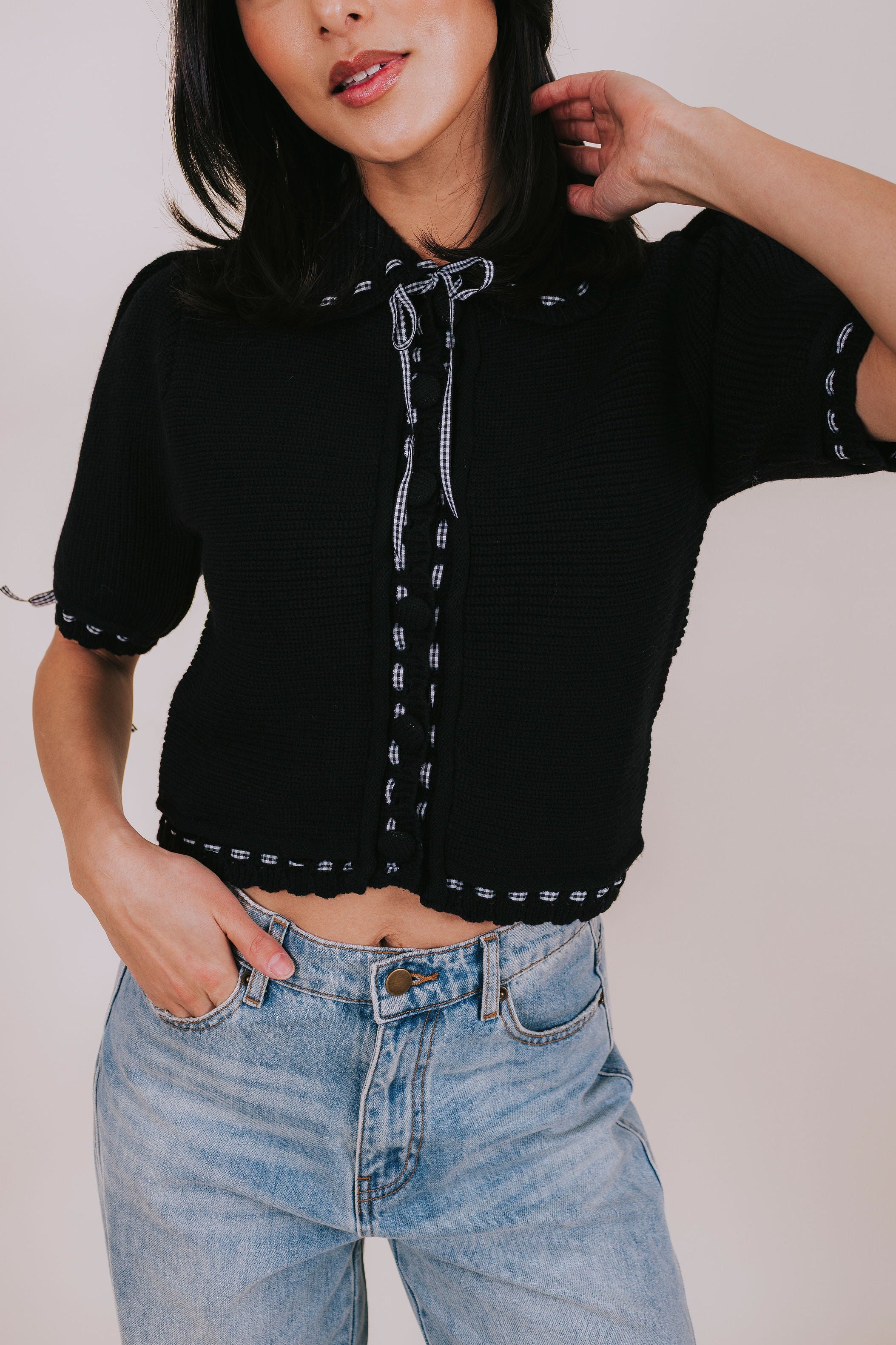 black knit collared top with gingham details close up