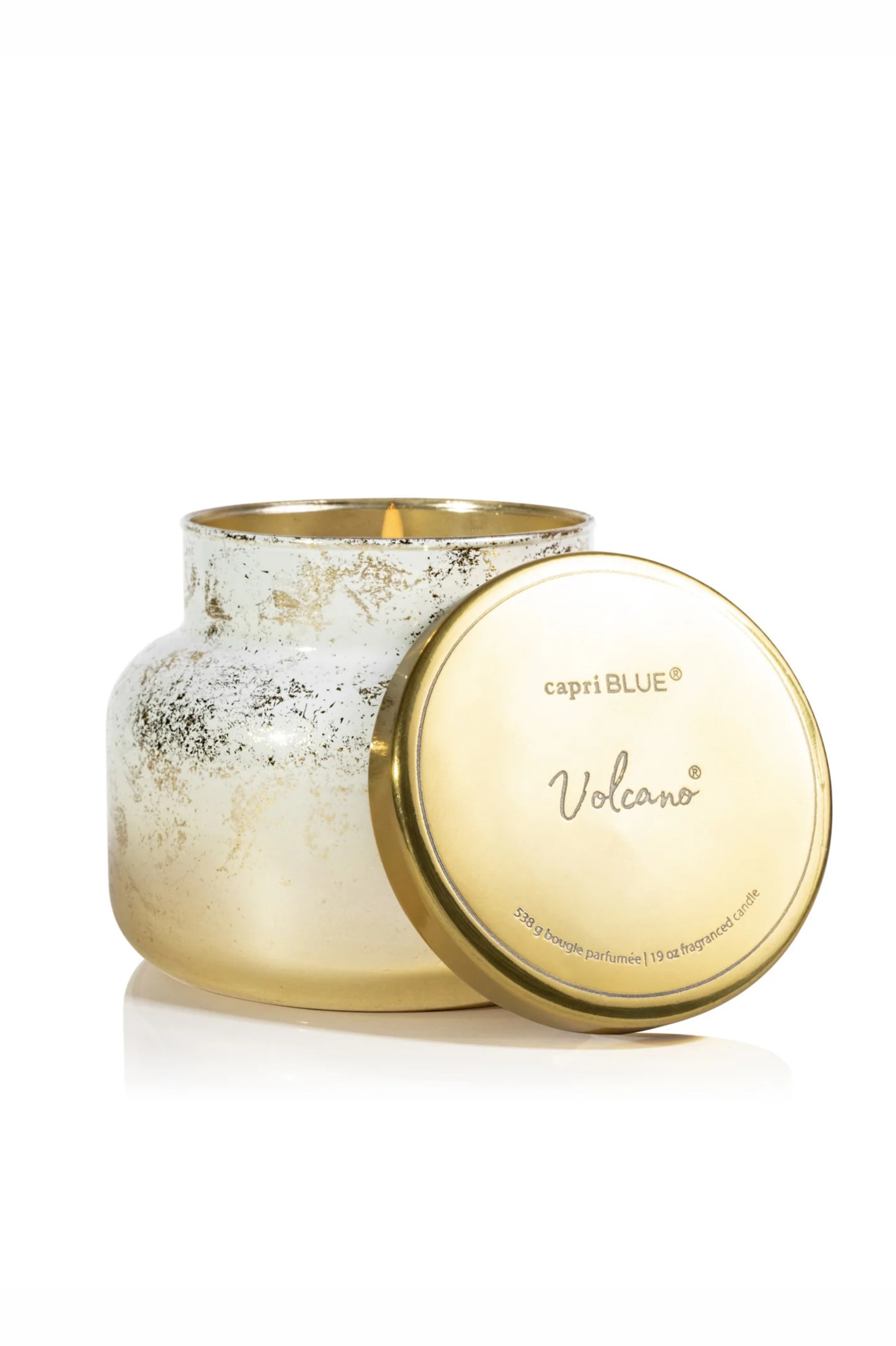 White to gold brushed gradient candle with a gold lid in volcano by capri blue.
