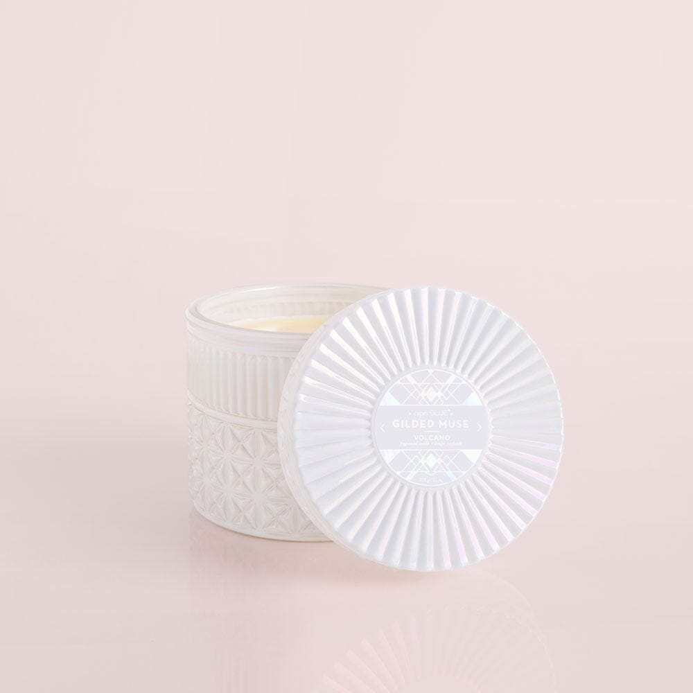 White textured candle with lid on a light pink background