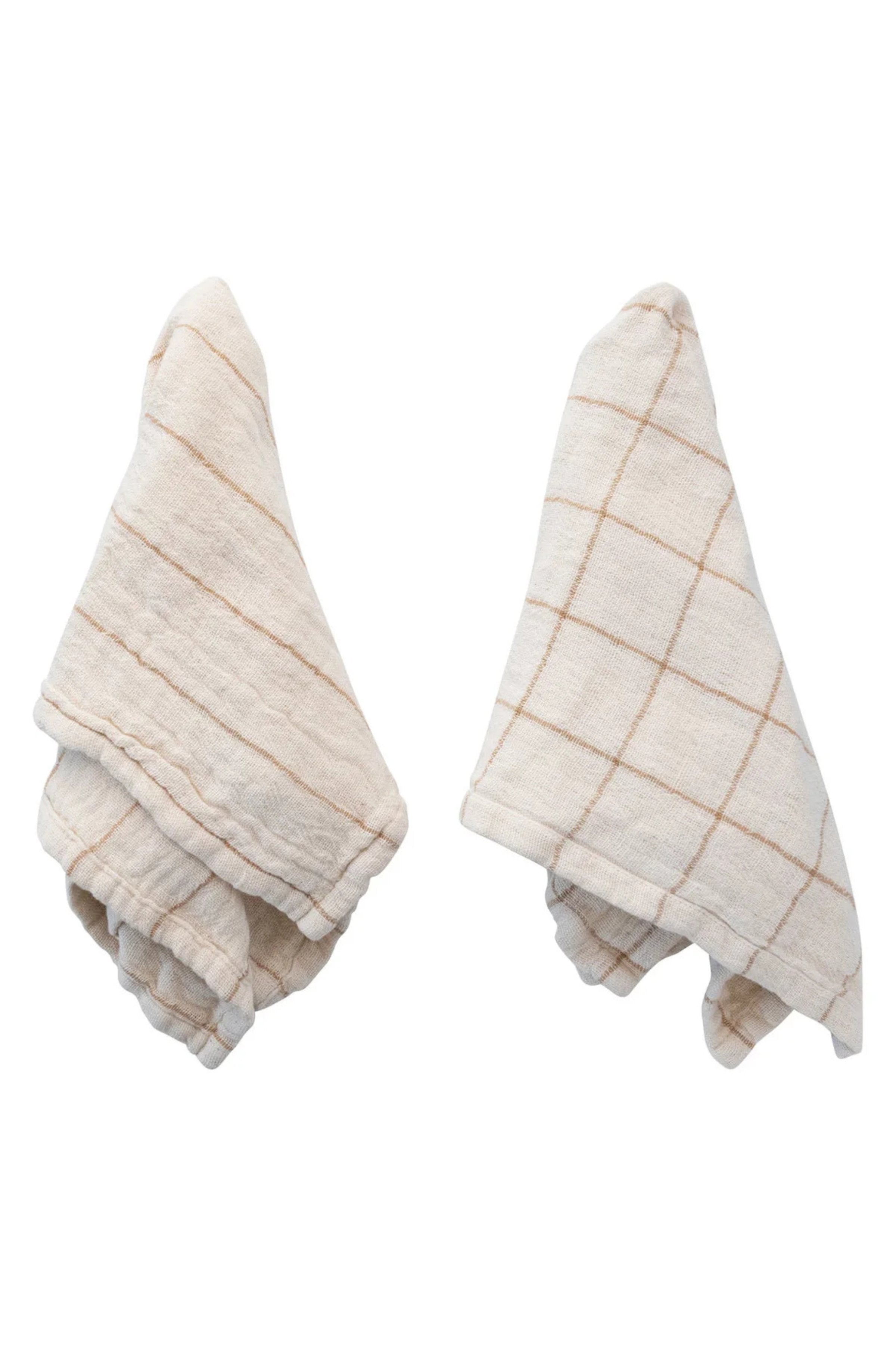 Two beige kitchen towels with grid patterns on a white background
