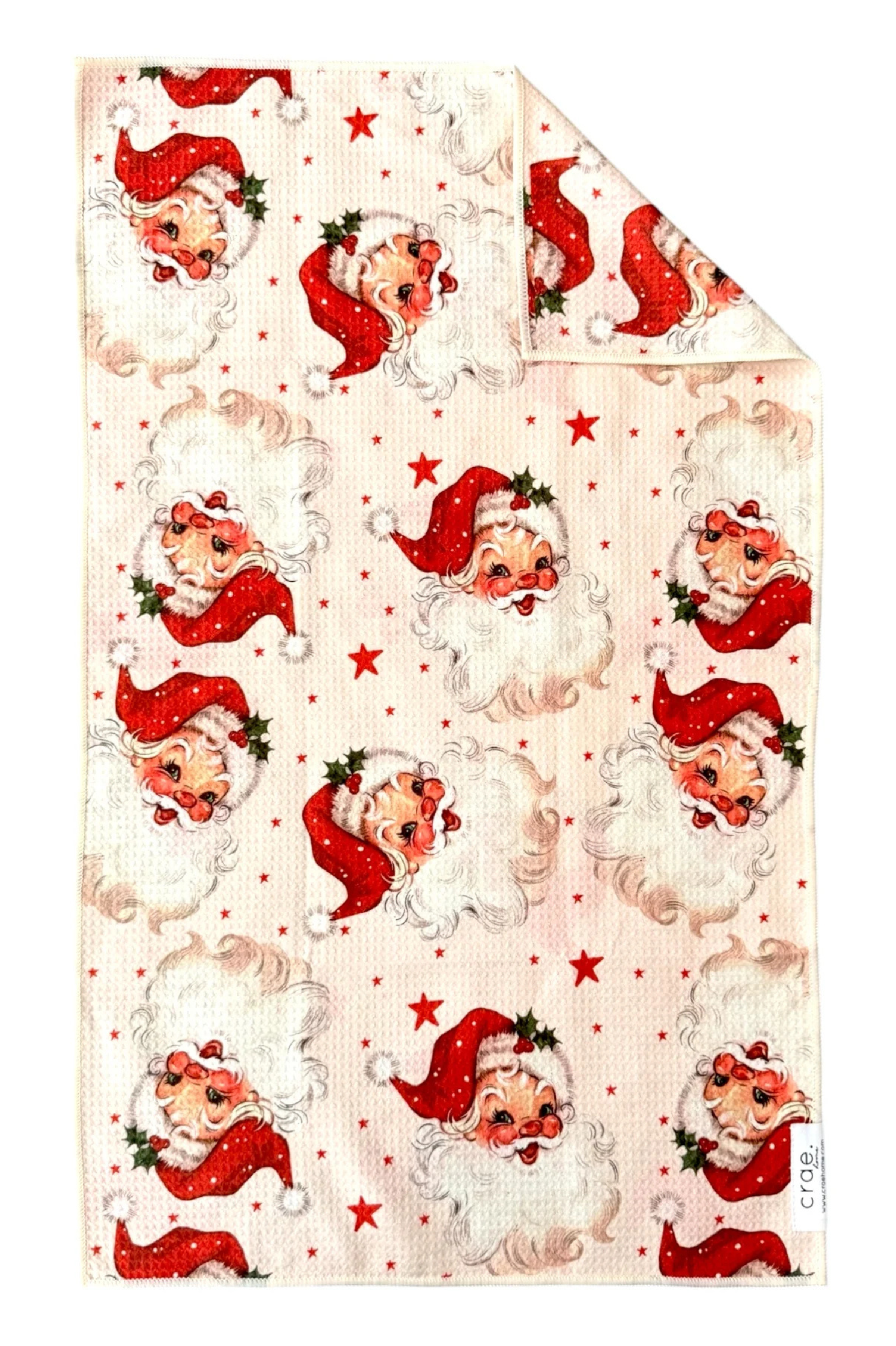 Microfiber hand towel patterned with red stars and Santa Claus faces.