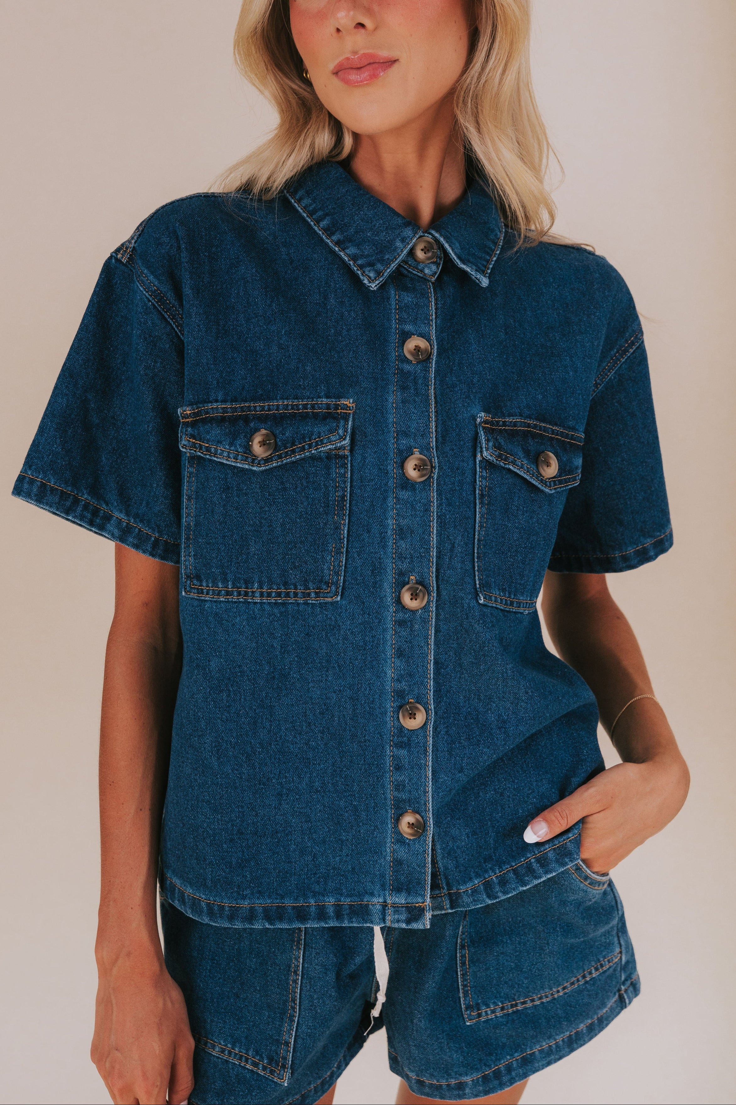 Jean shirt with front breast pockets and a collar. Button down front with short sleeves denim material 