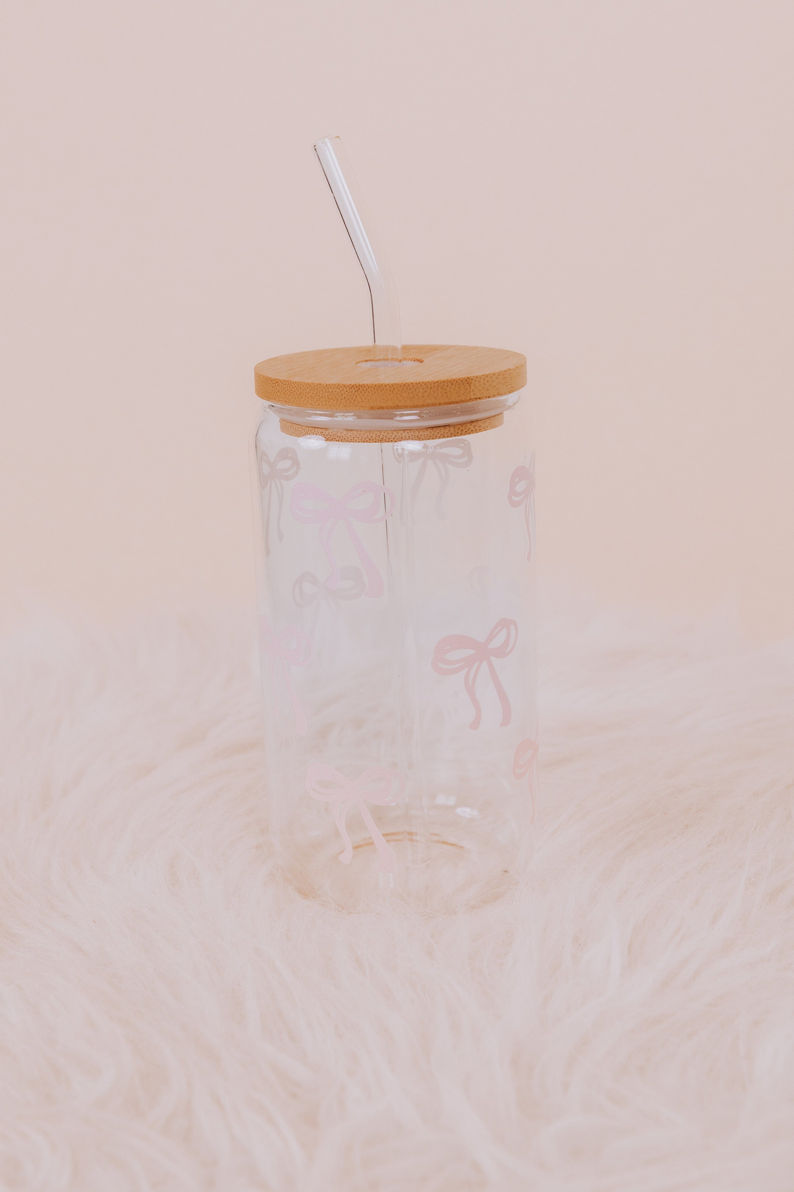 Clear glass tumbler with wooden lid and straw with pink bow details