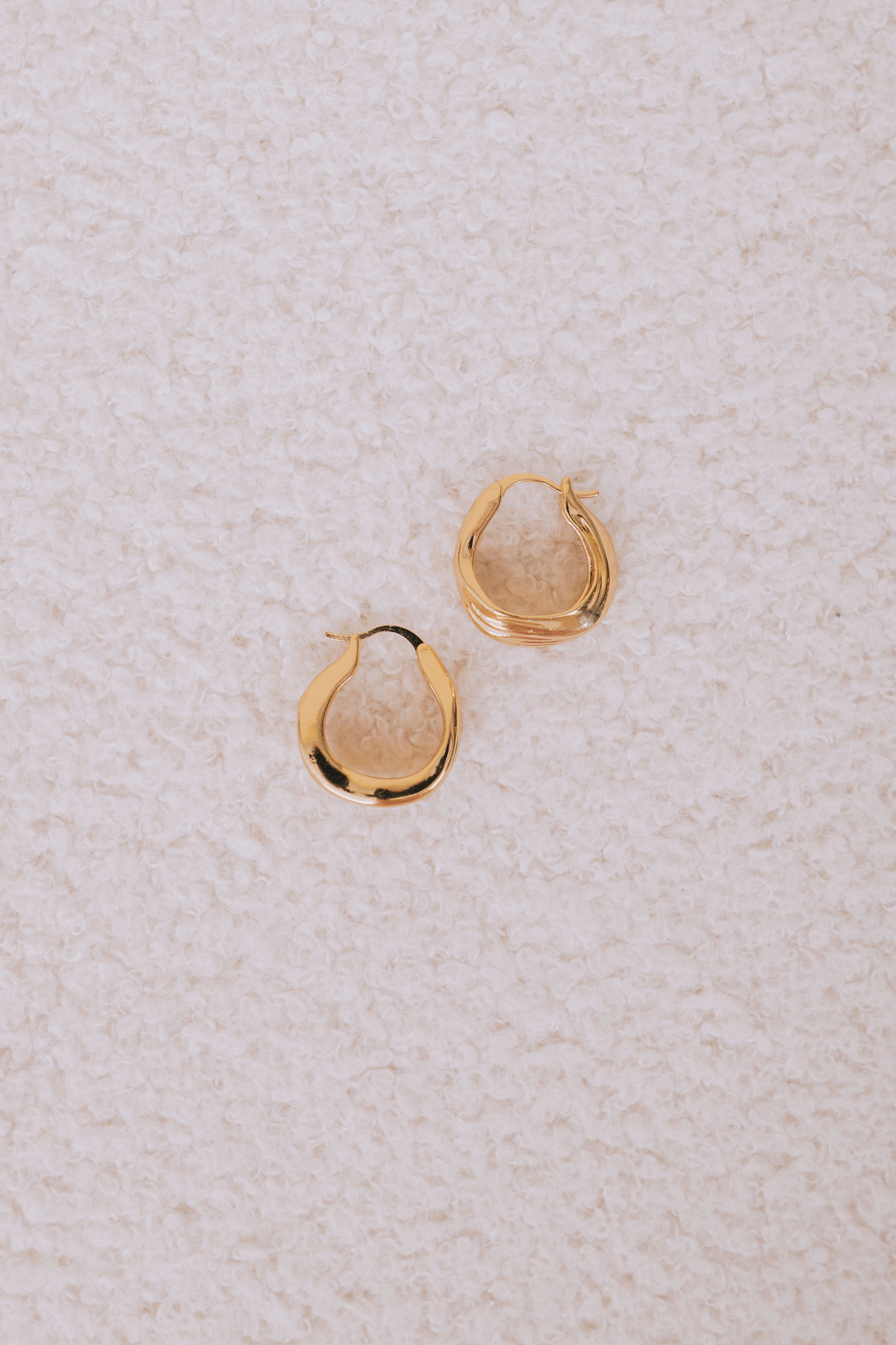 gold asymmetrical latch back earrings flatlay