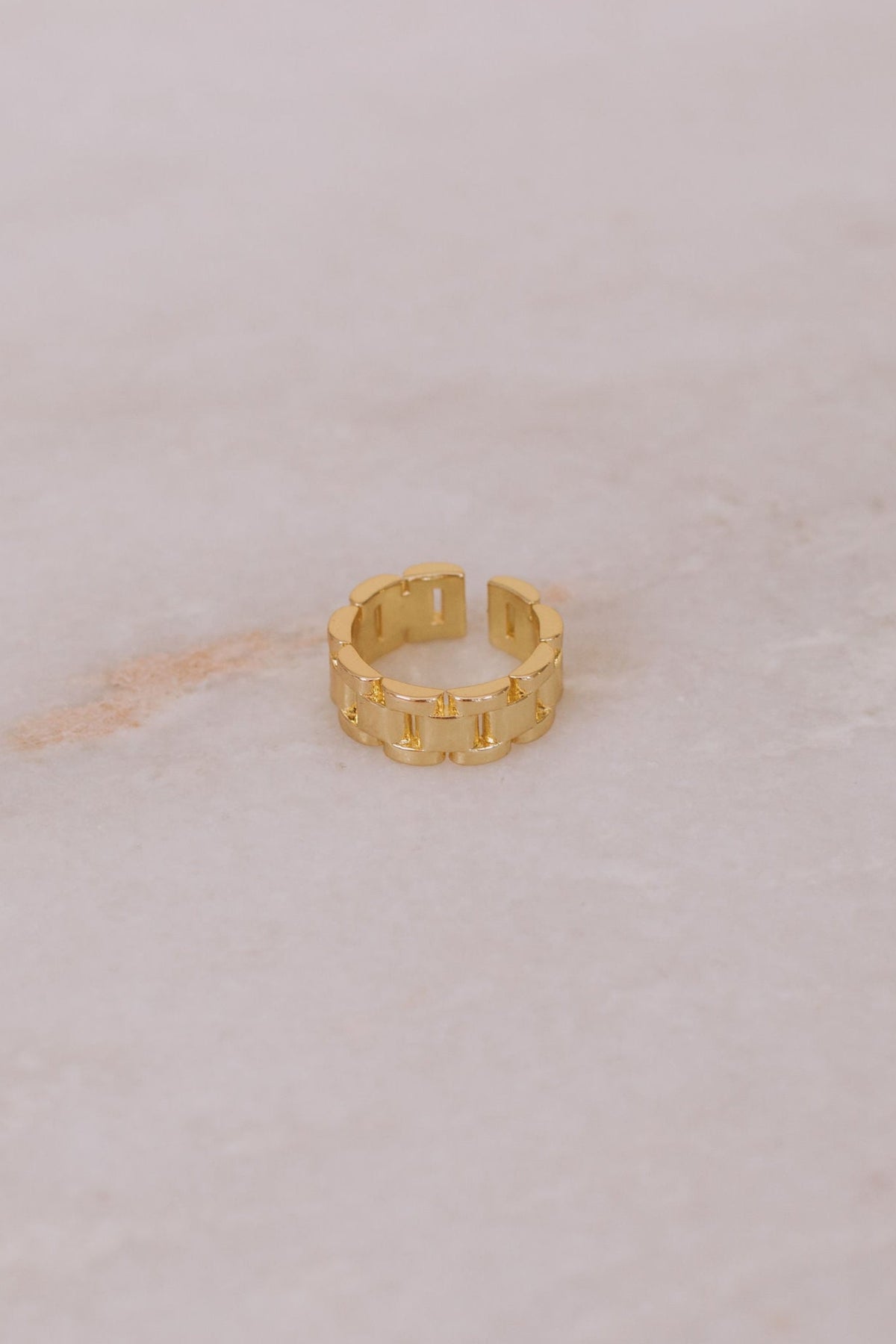 Open cuff ring shaped like a chain in gold. 