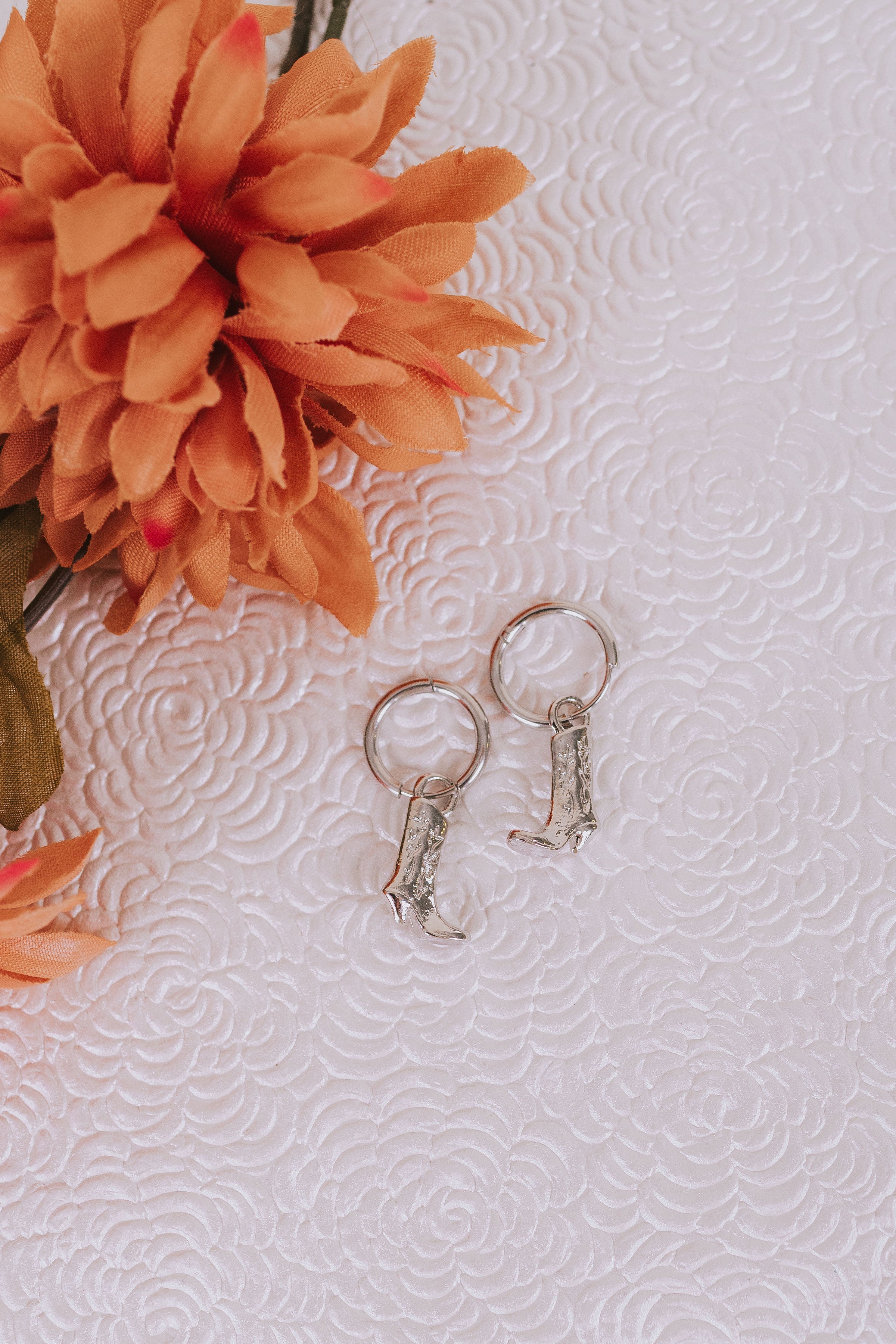 silver hoop huggie earrings with cowboy boot dangles 