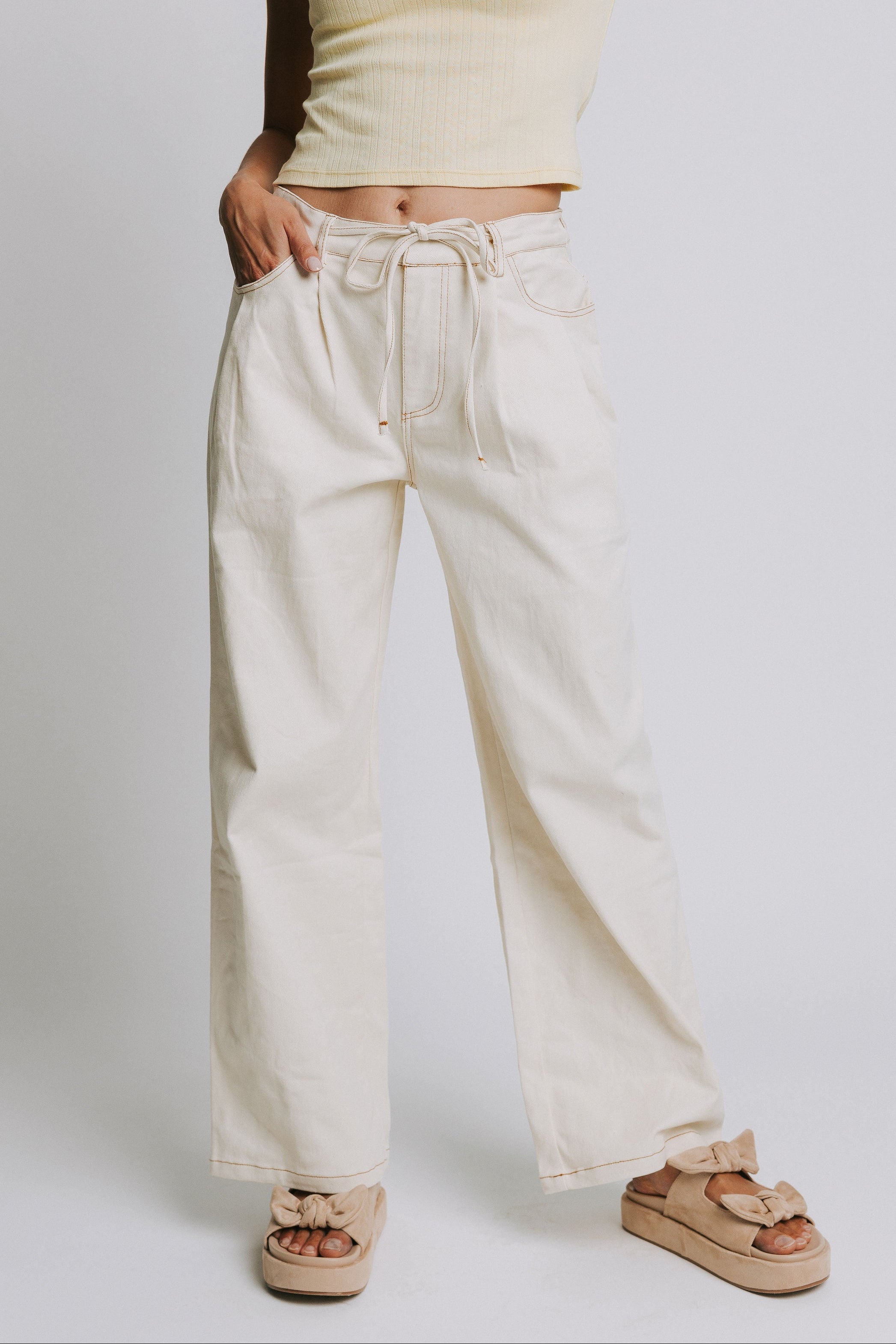 ivory jeans with tie at the waist and contrast stitching
