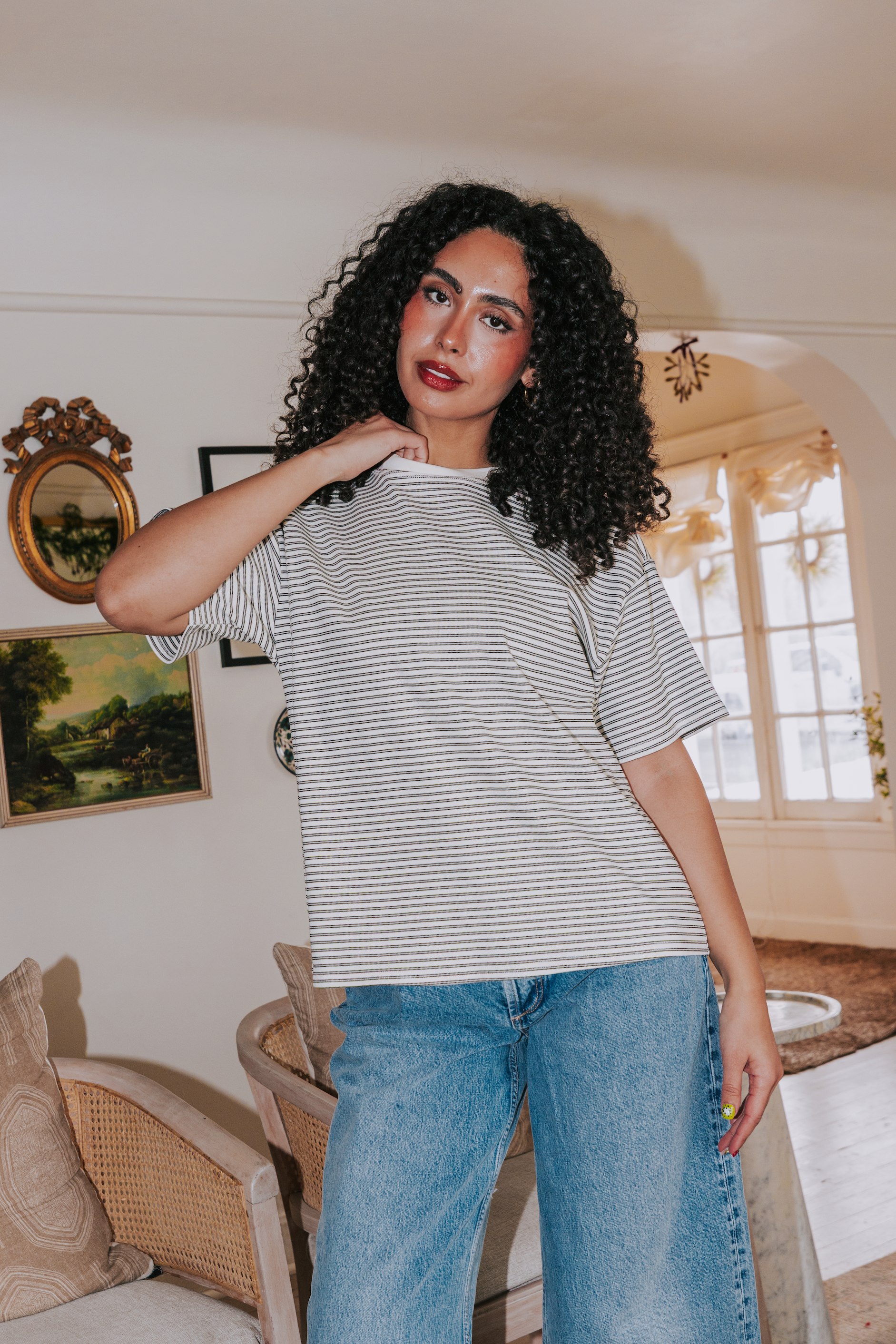 Woman wearing a striped shirt and jeans in a living room setting