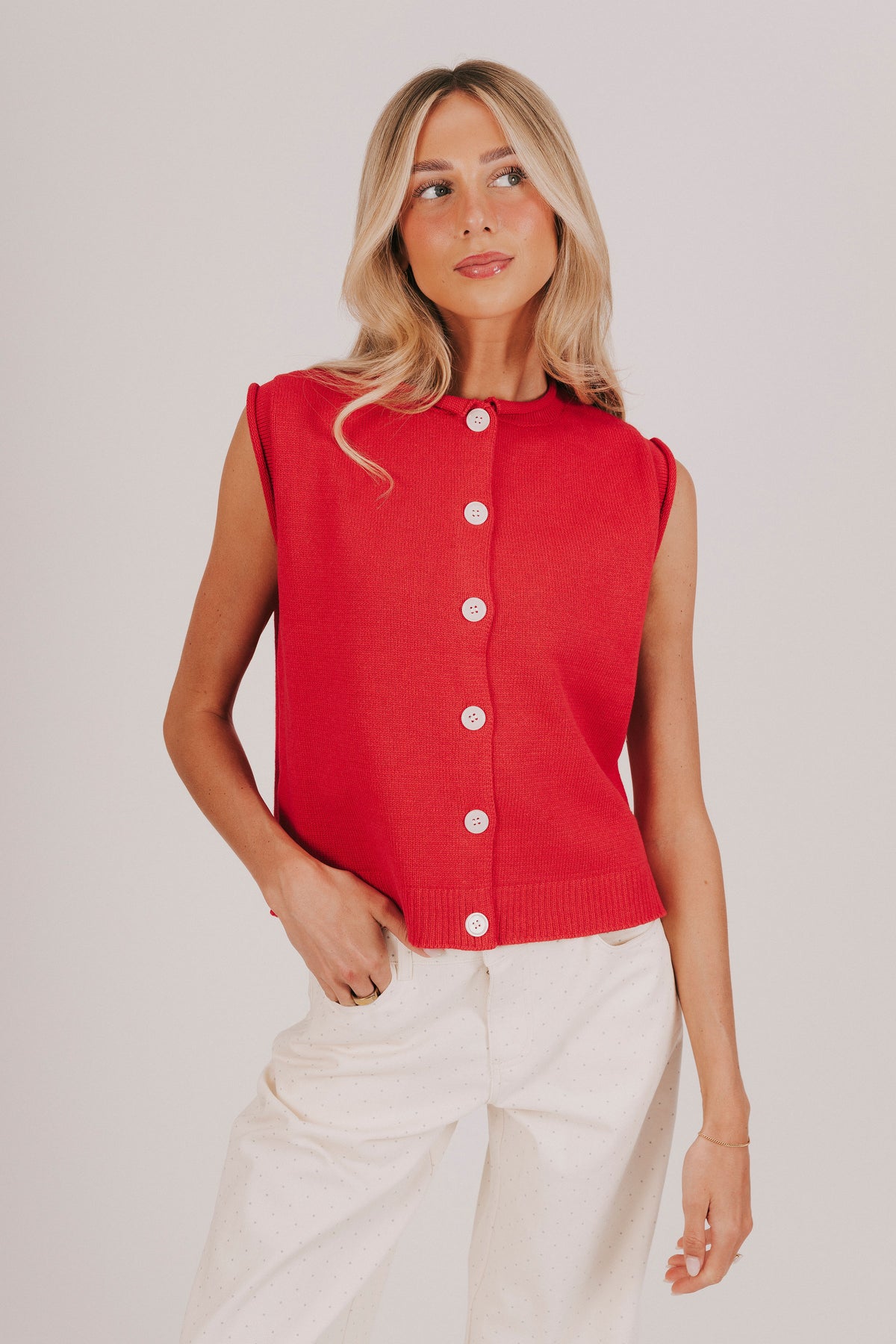 red sleeveless knit top with a button down front and rolled edges 