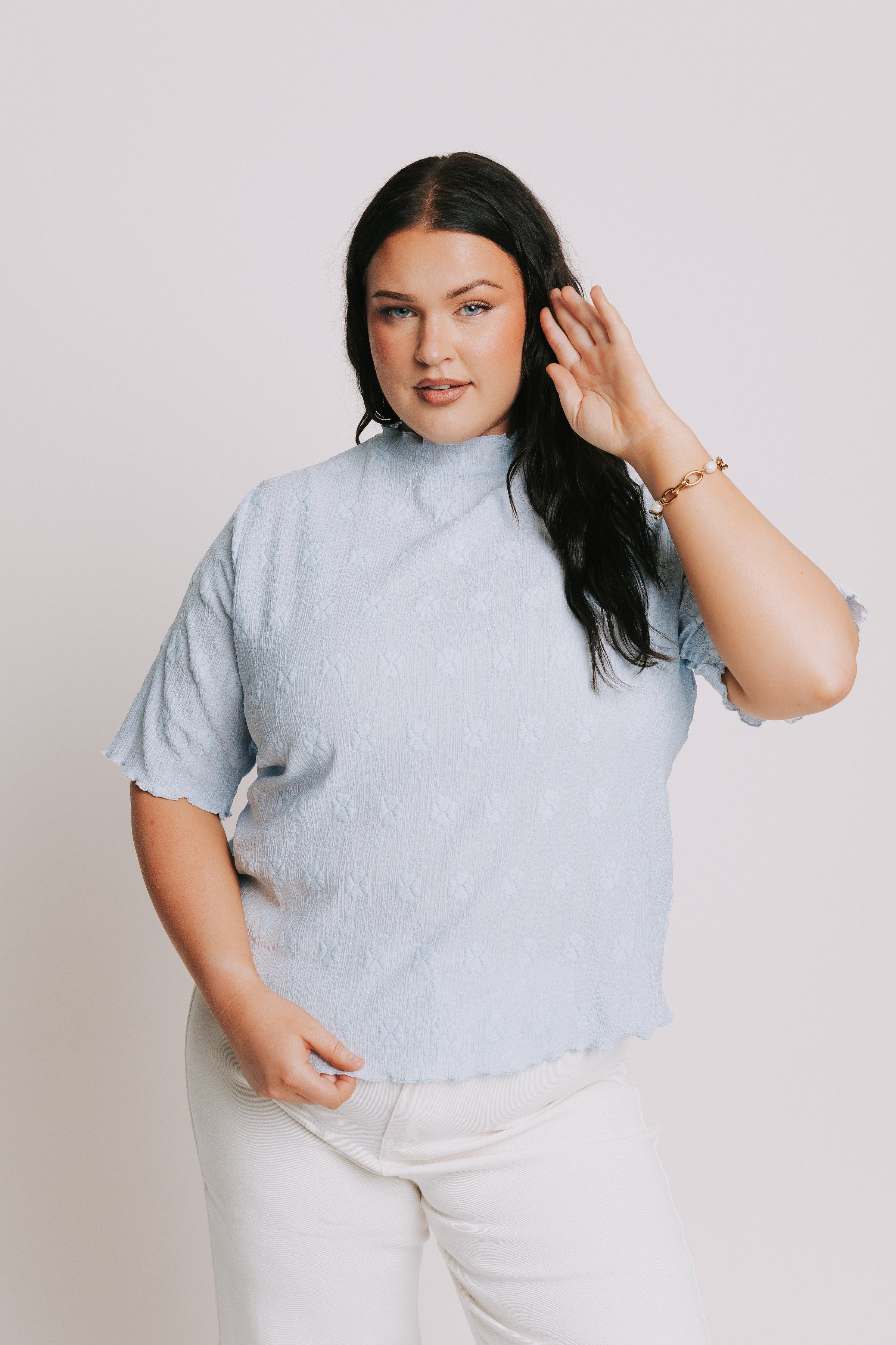 light blue top with textured pattern and mock neck
