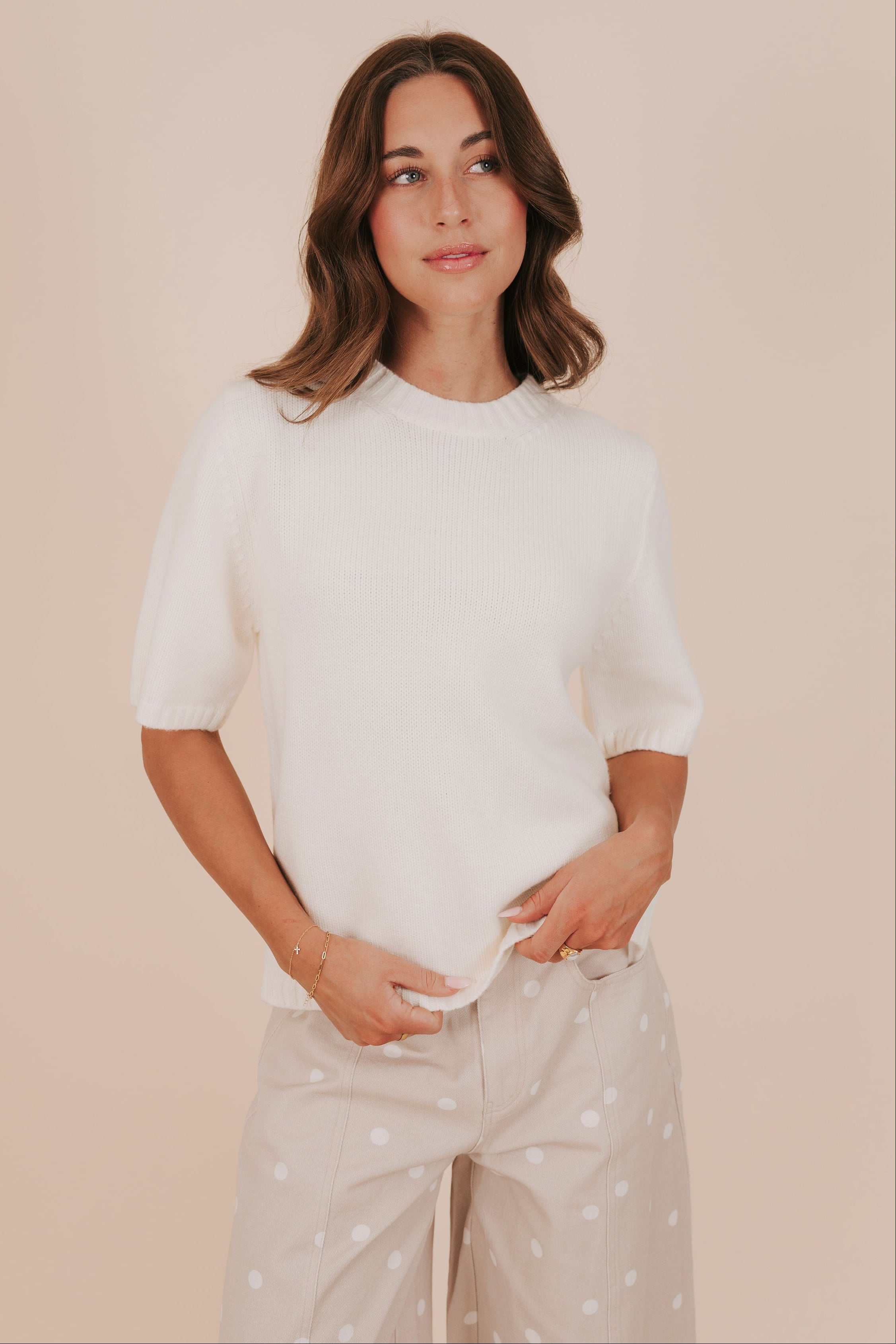 Cream colored short sleeves sweater with ribbed accents and split hem. 