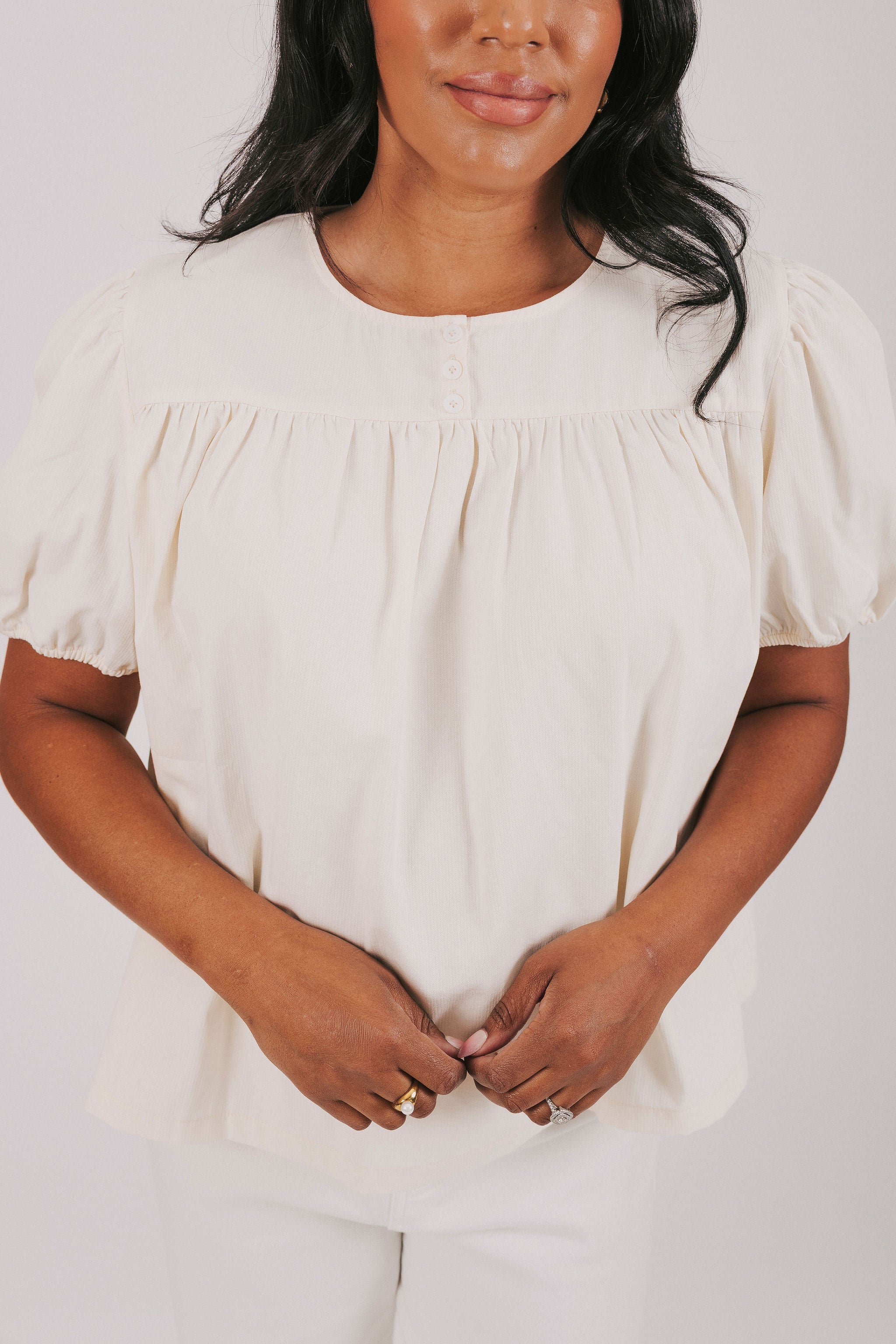 ivory colored blouse with short puff sleeves and gathered detail 