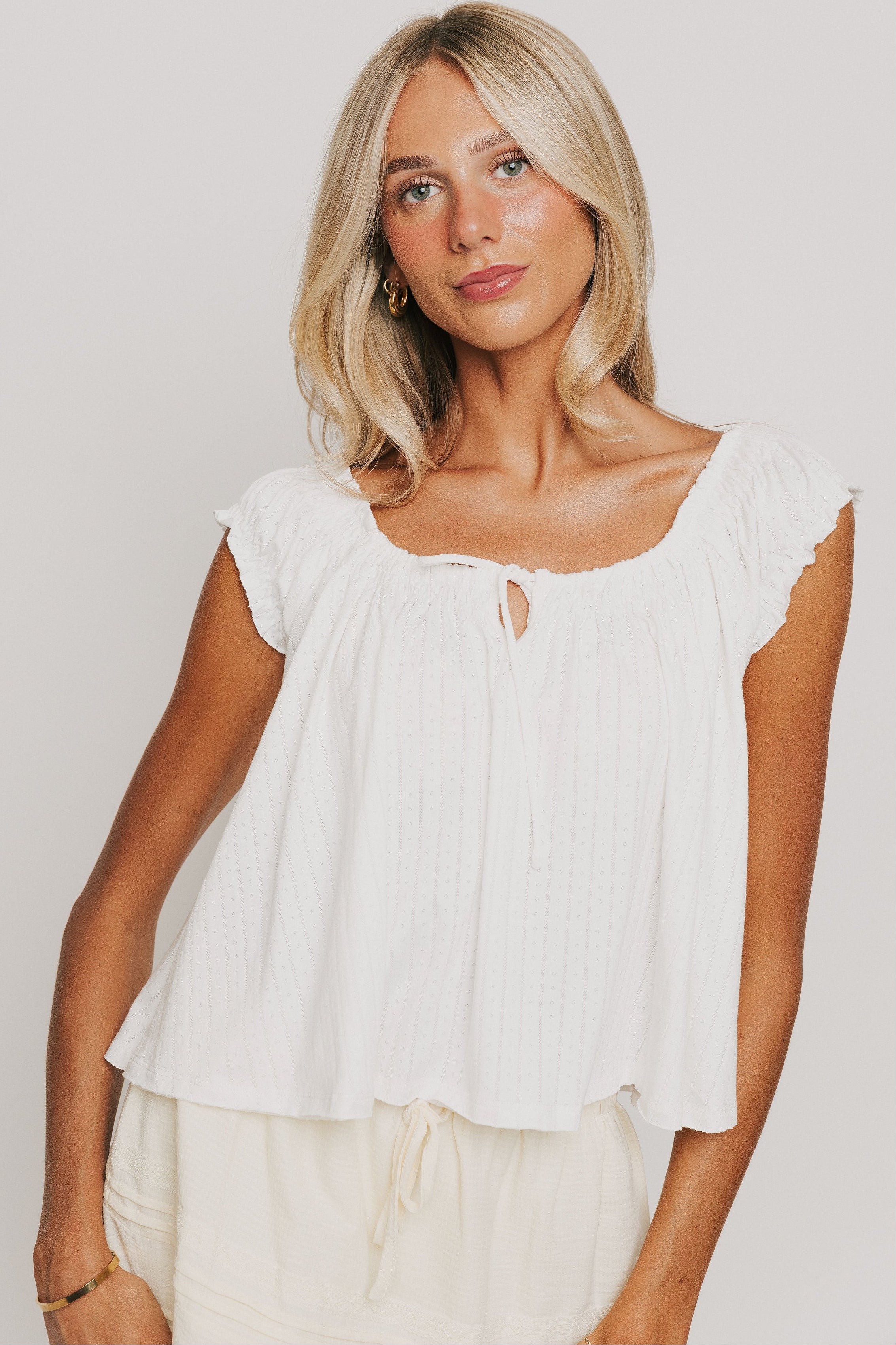 off white top with ruffled cap sleeves and keyhole