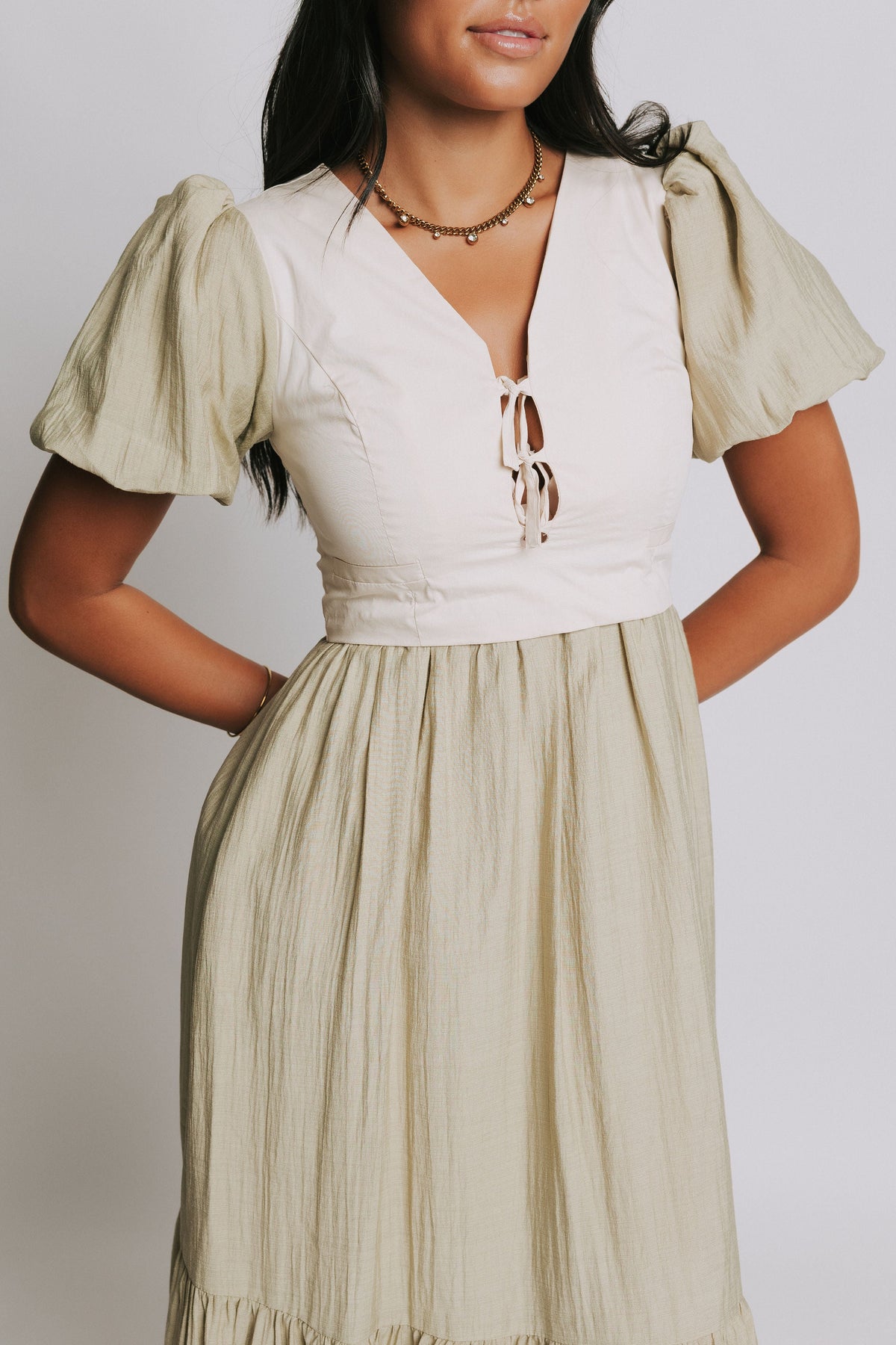 olive midi dress with cream vest and puff sleeves front